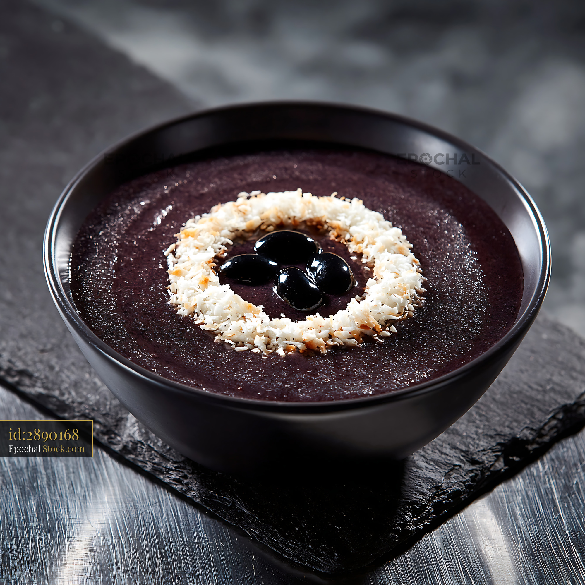 Black rice sikhye smoothie bowl topped with coconut and beans - stock photo