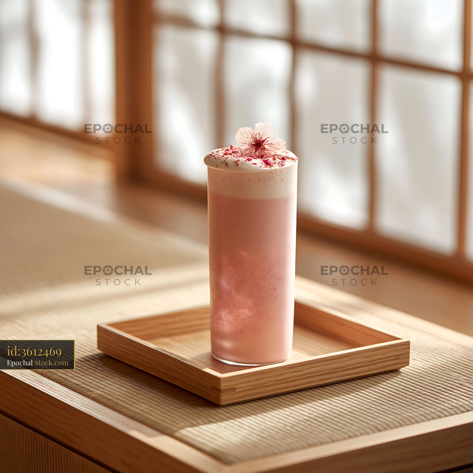 Pink sakura blossom smoothie on a wooden tray in a sunlit room - stock photo