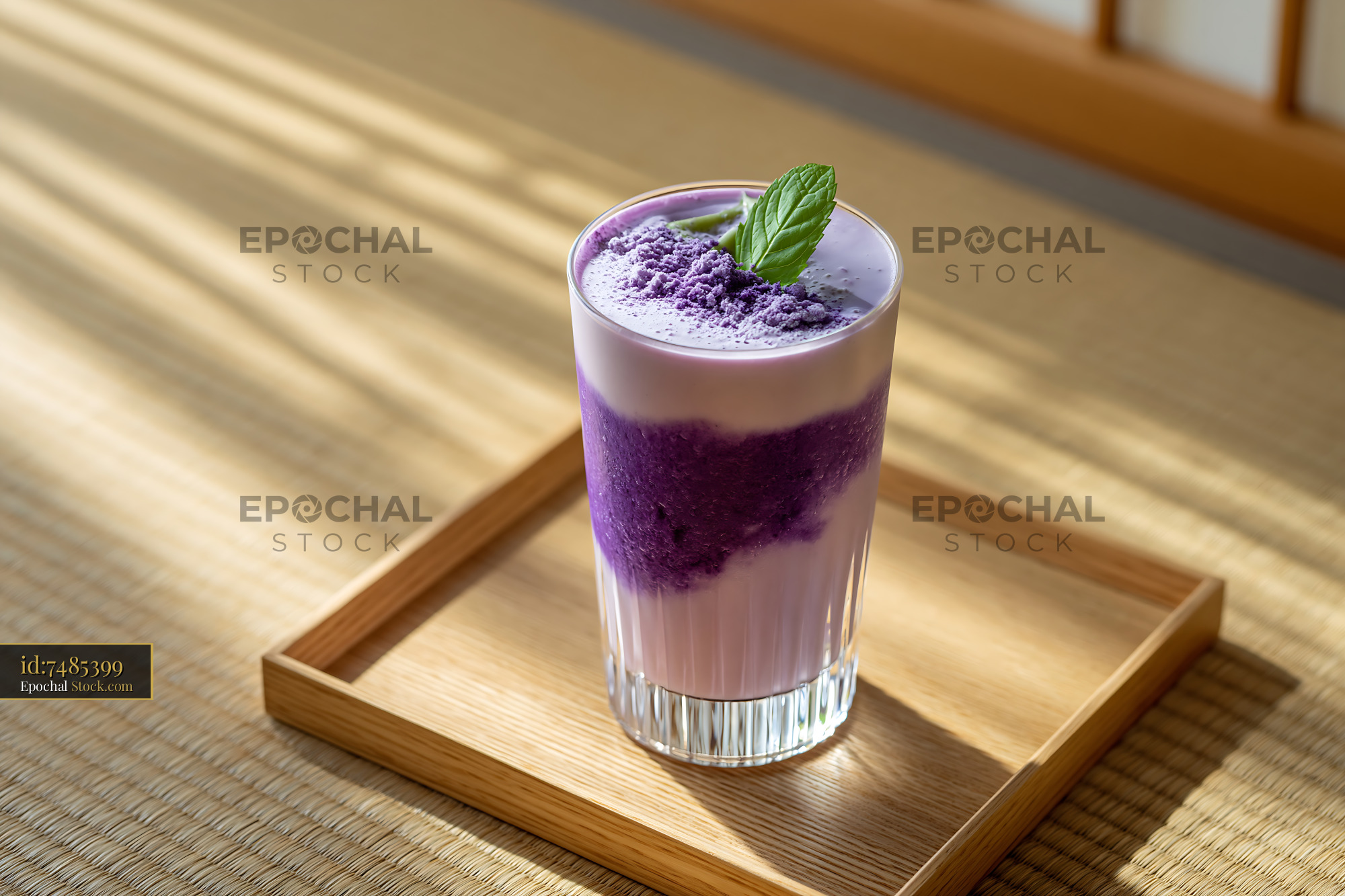 Beni imo smoothie with mint leaf on wooden tray in warm light - stock photo