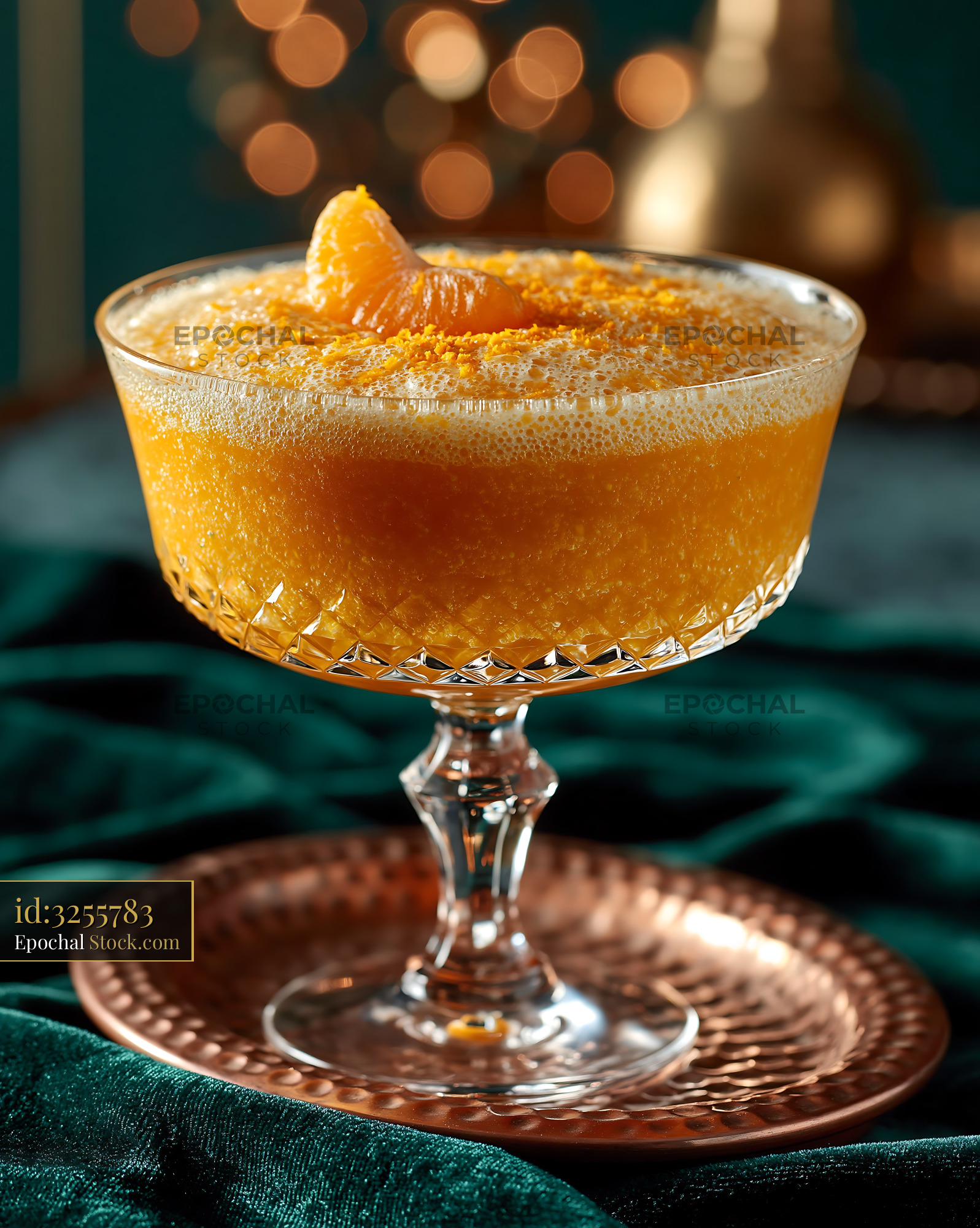 Mikan orange smoothie in crystal glass on dark green velvet - stock photo