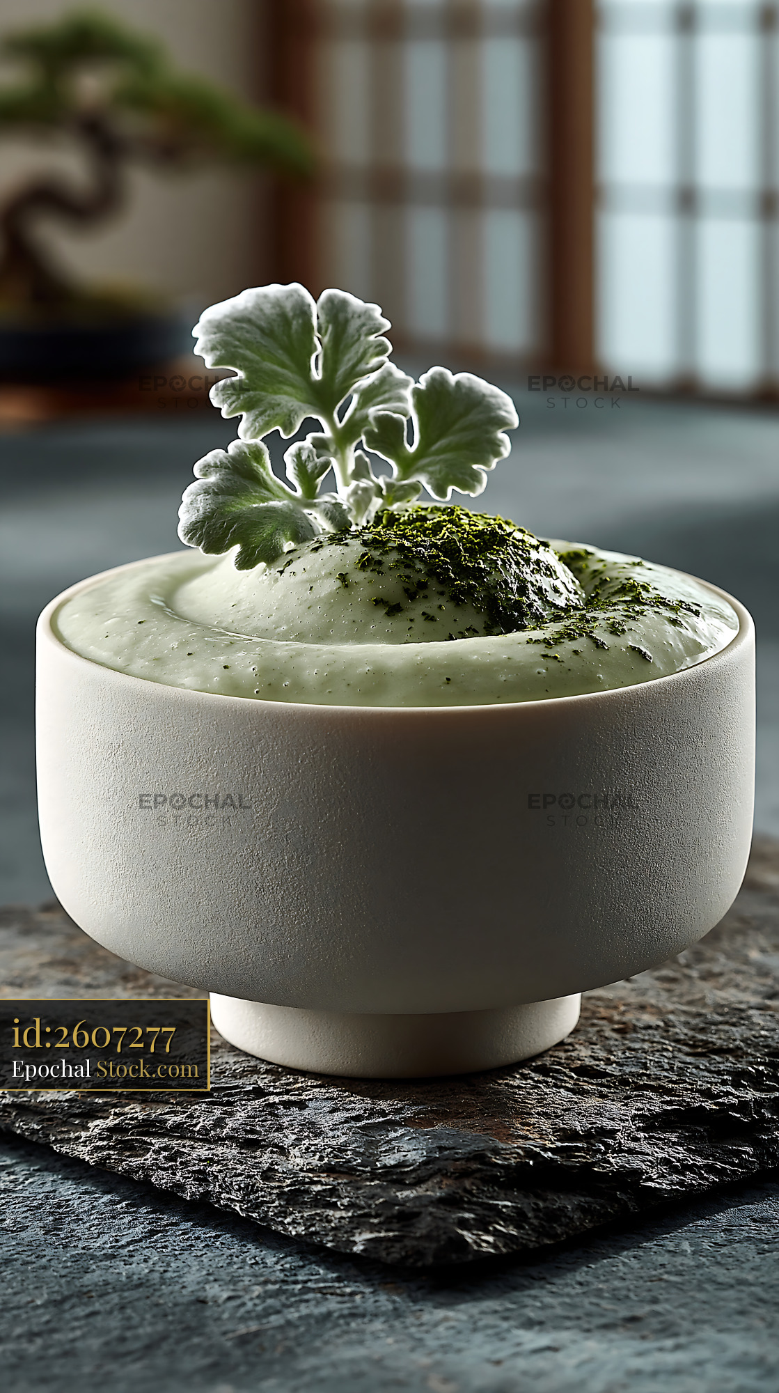 Mugwort herb smoothie in a white ceramic bowl on a stone coaster - stock photo