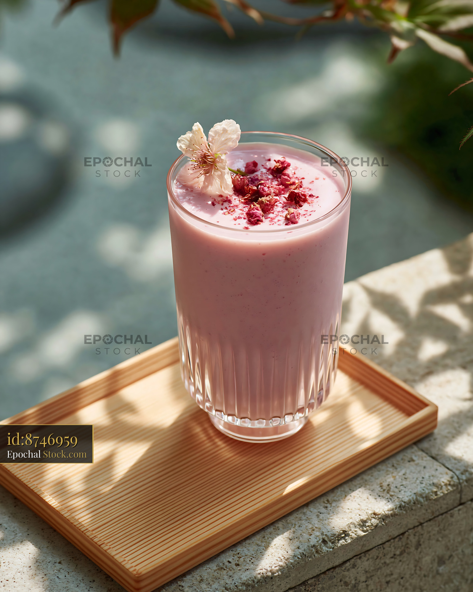 Sakura blossom smoothie in a fluted glass on a wooden tray - stock photo