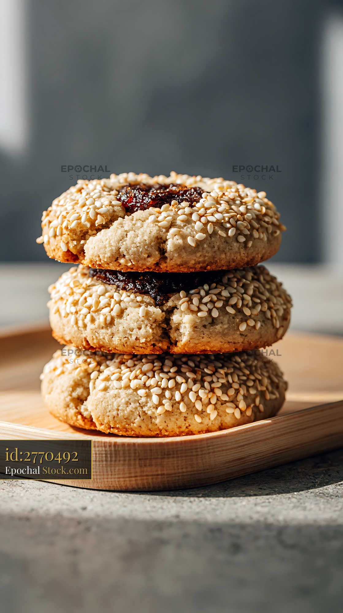 Stack of tahini date biscuits with sesame seeds on a wooden tray - stock photo