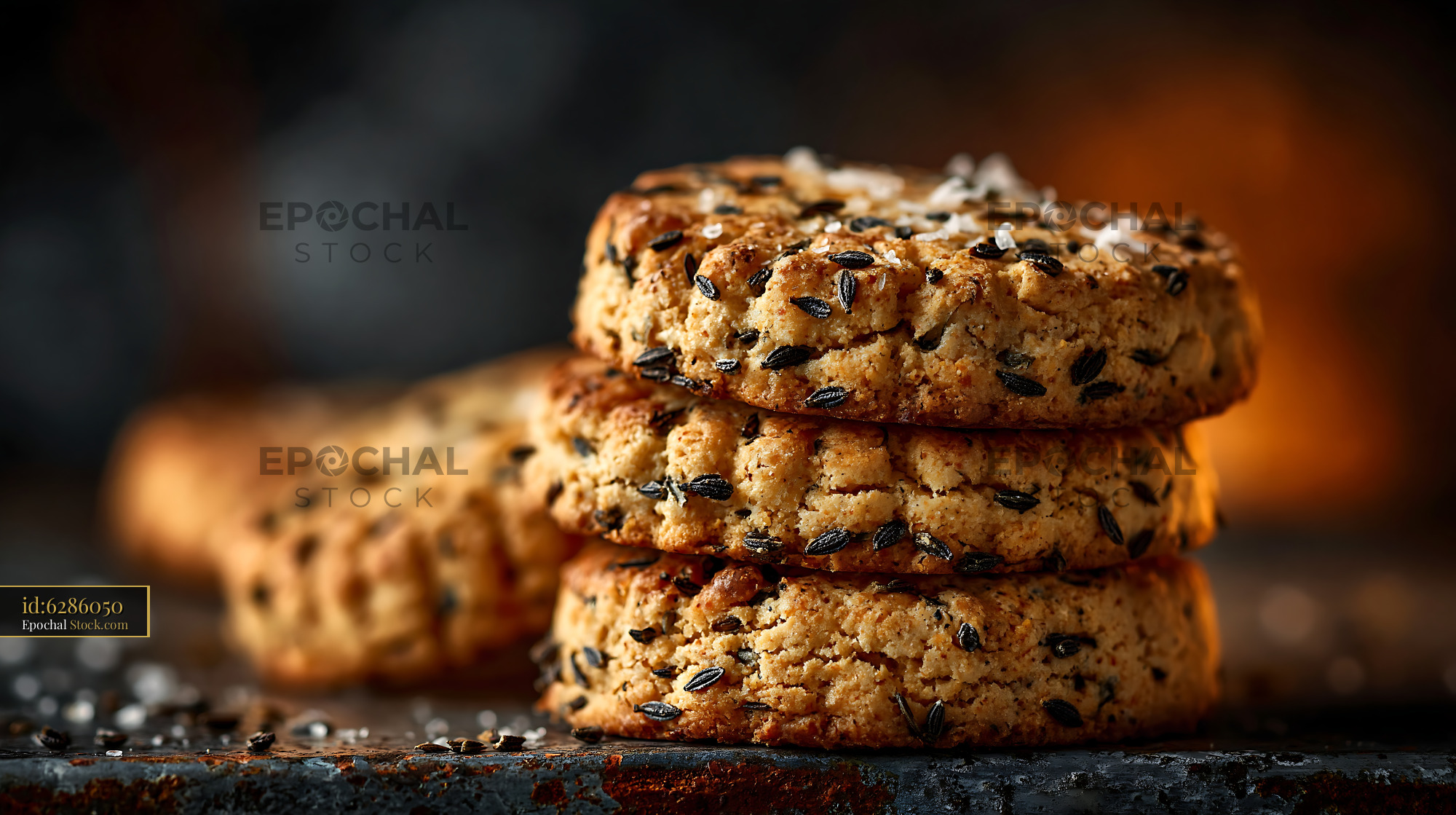 Stack of rustic caraway seed biscuits with sea salt on a dark surface - stock photo
