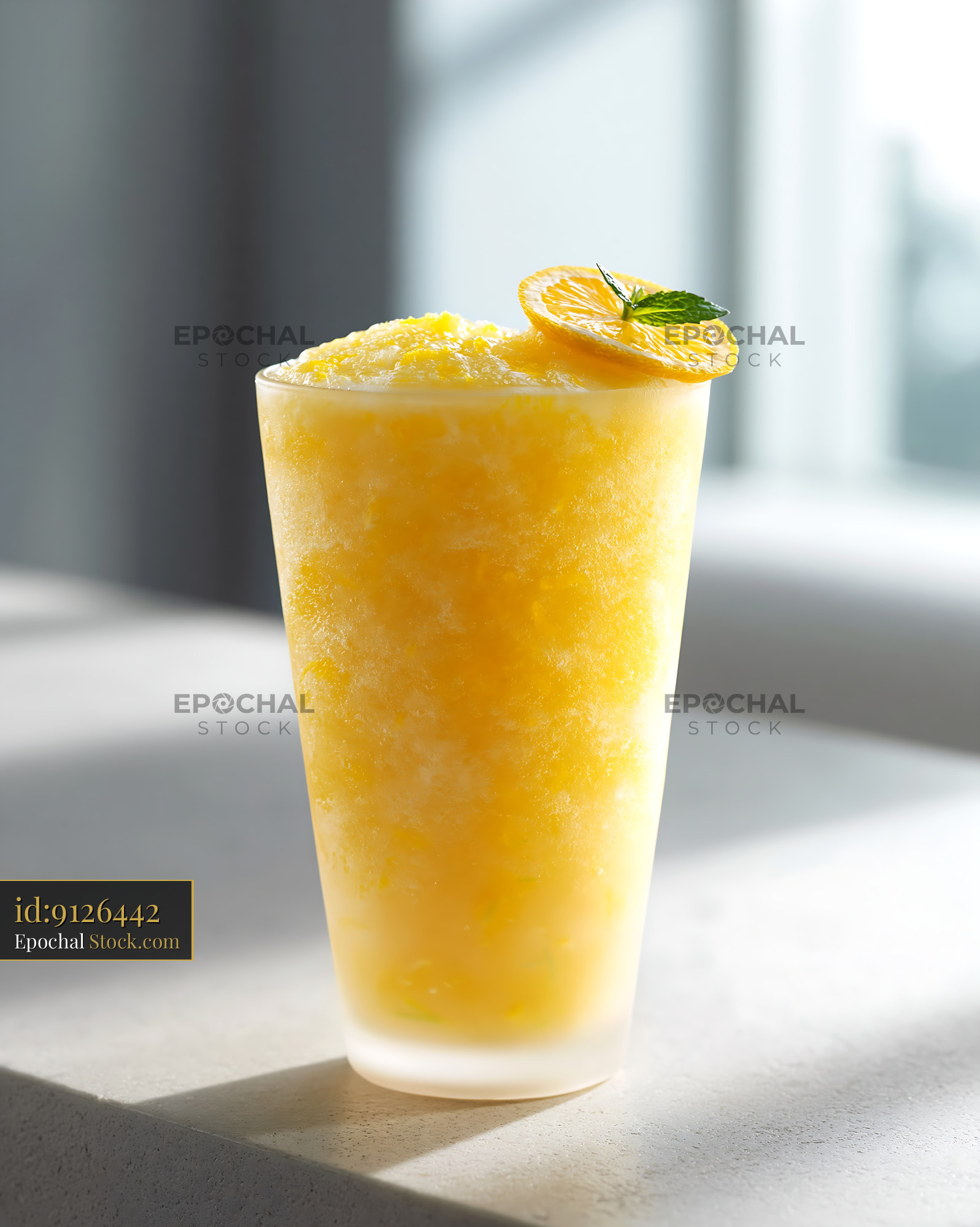 Yuja citron smoothie in a tall glass with orange slice garnish - stock photo