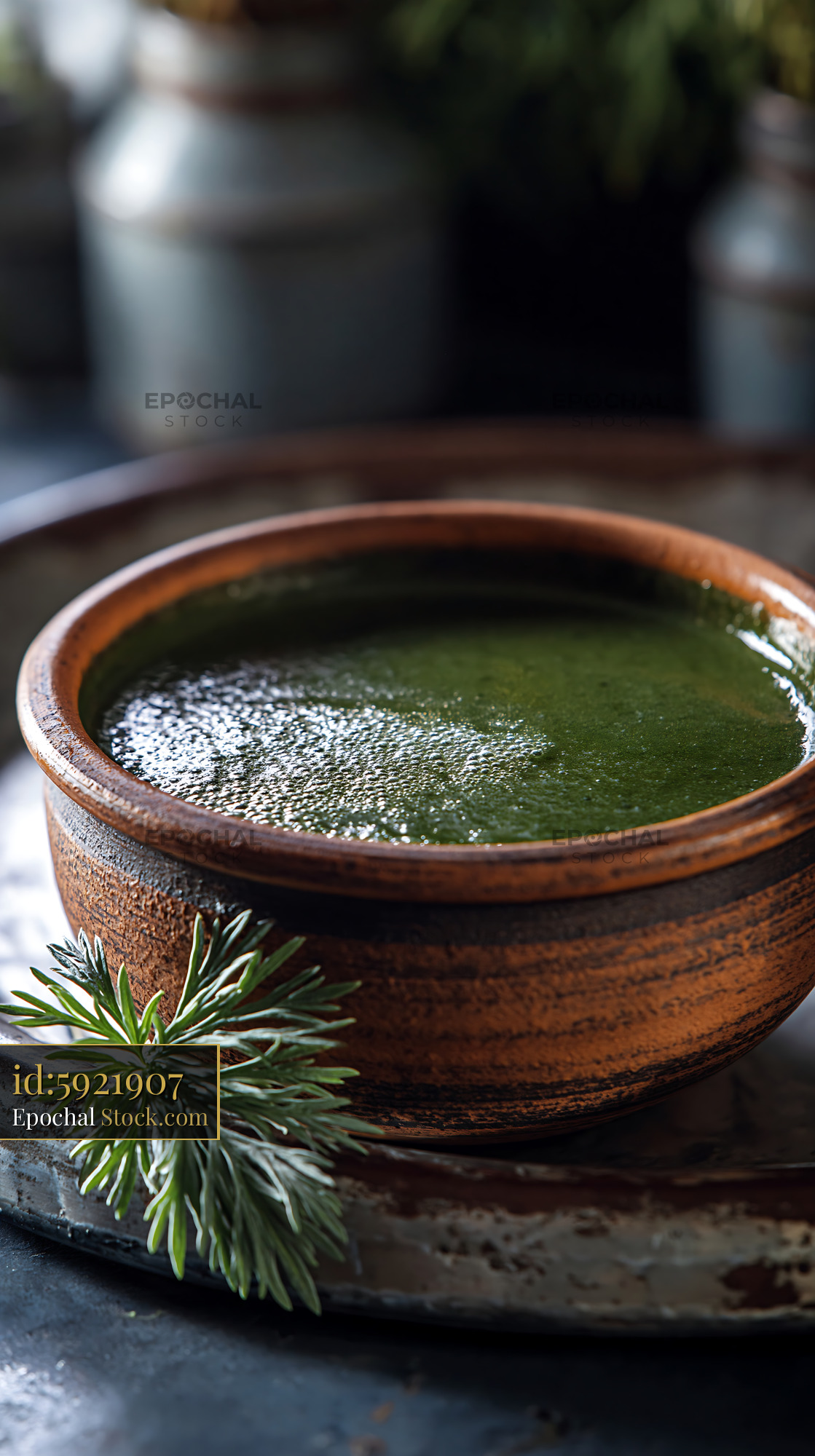 Mugwort herb smoothie in a rustic ceramic bowl with fresh sprigs - stock photo