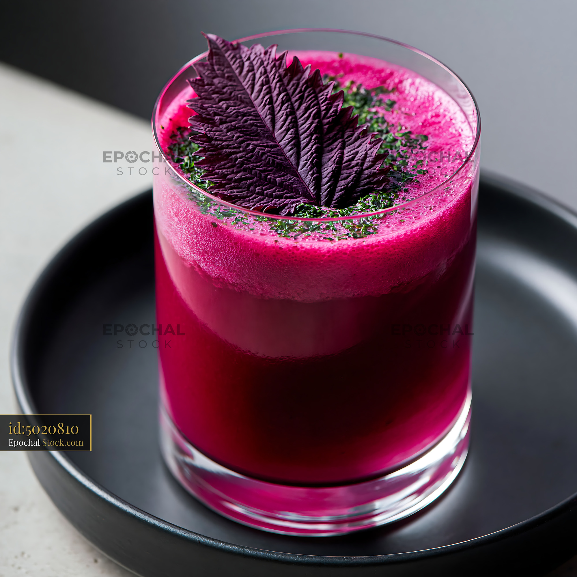 Vibrant pink shiso leaf smoothie with herbal garnish in a glass - stock photo