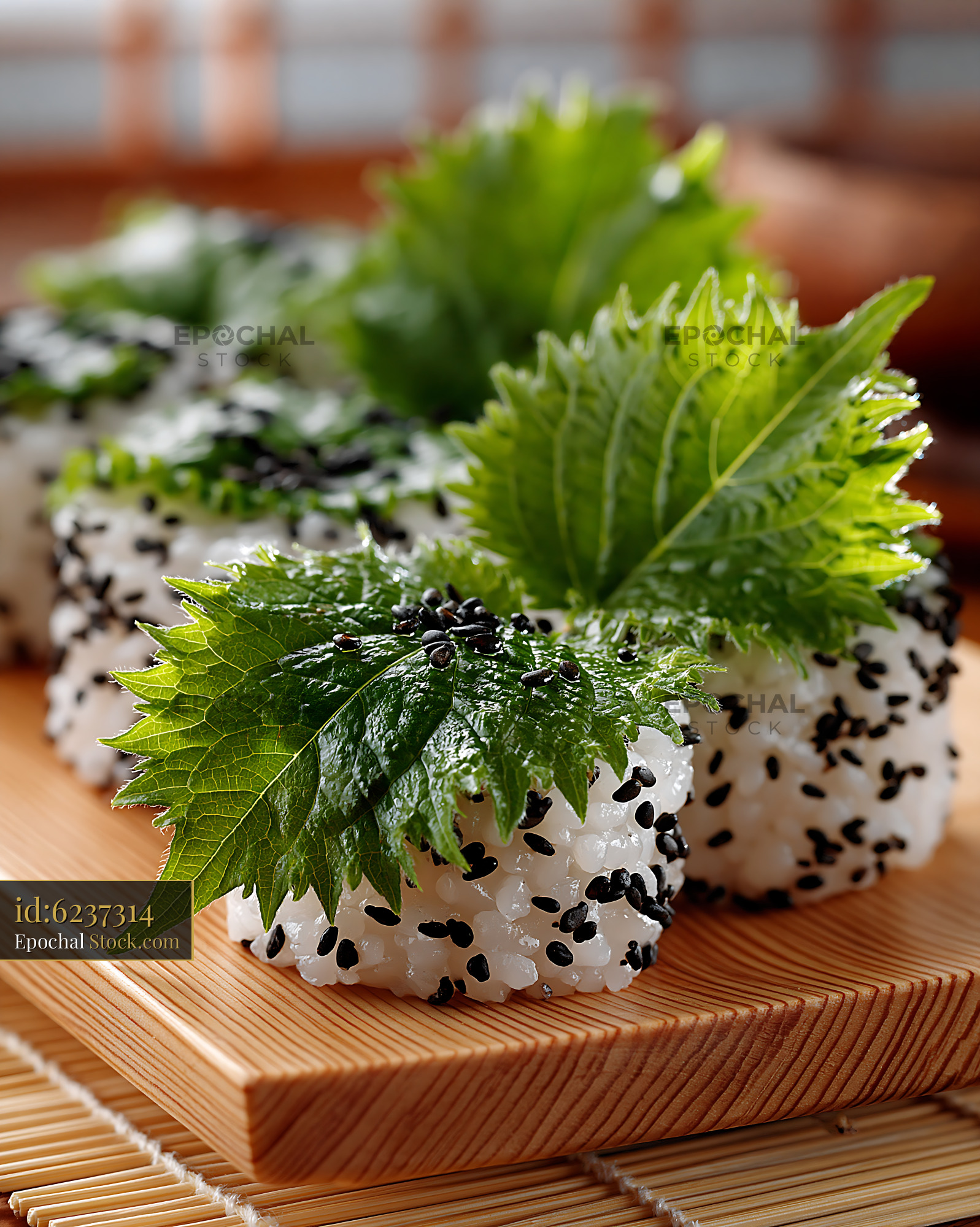Shiso leaf uramaki sushi with black sesame on a wooden board - stock photo