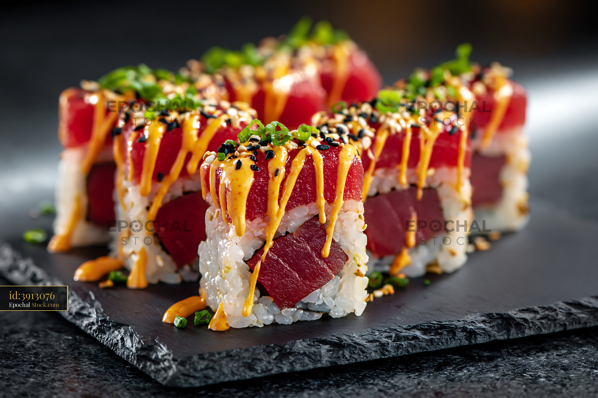 Fresh sriracha mayo tuna sushi rolls topped with sesame and chives - stock photo