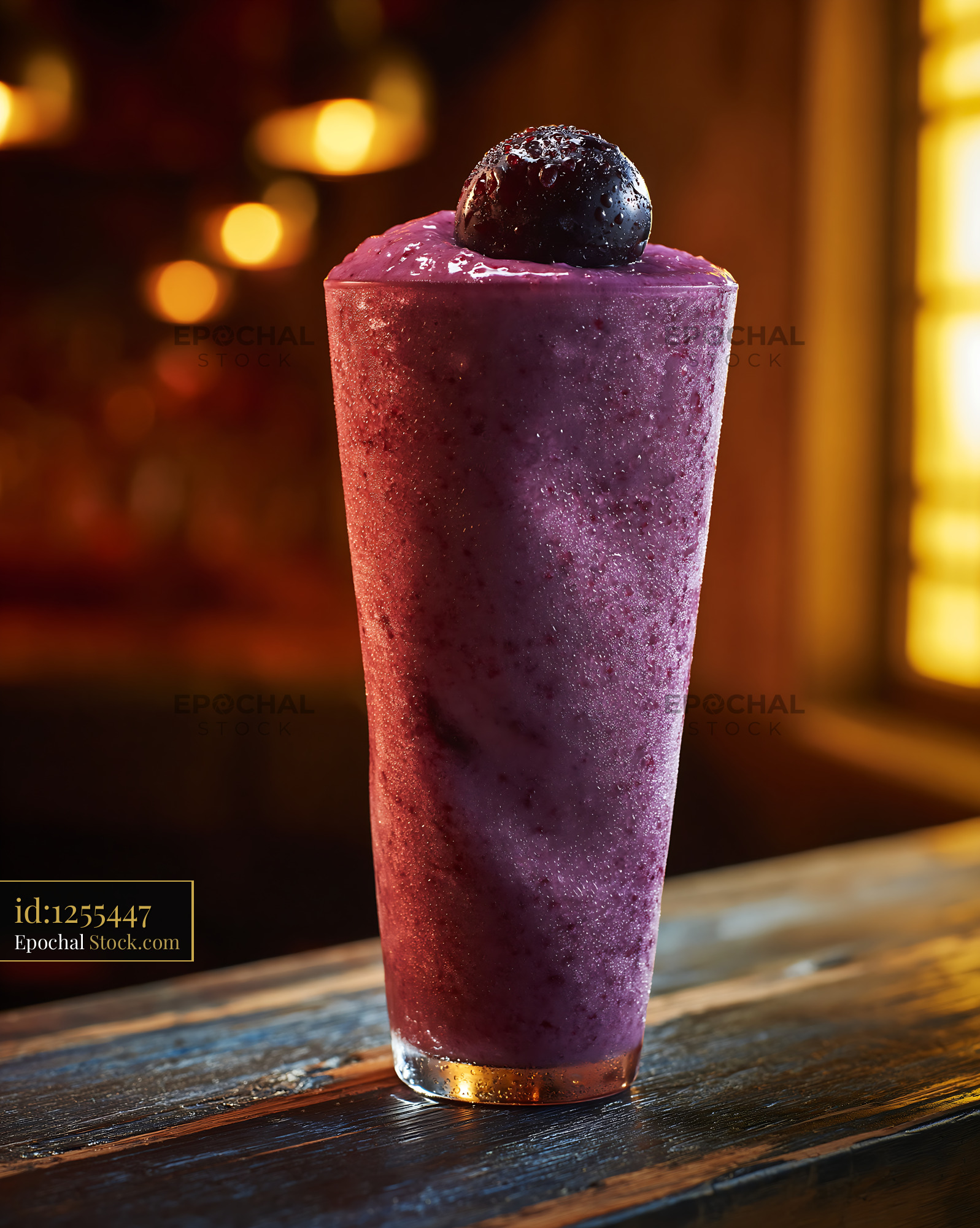 Fresh kyoho grape smoothie topped with a whole grape in a warm bar - stock photo