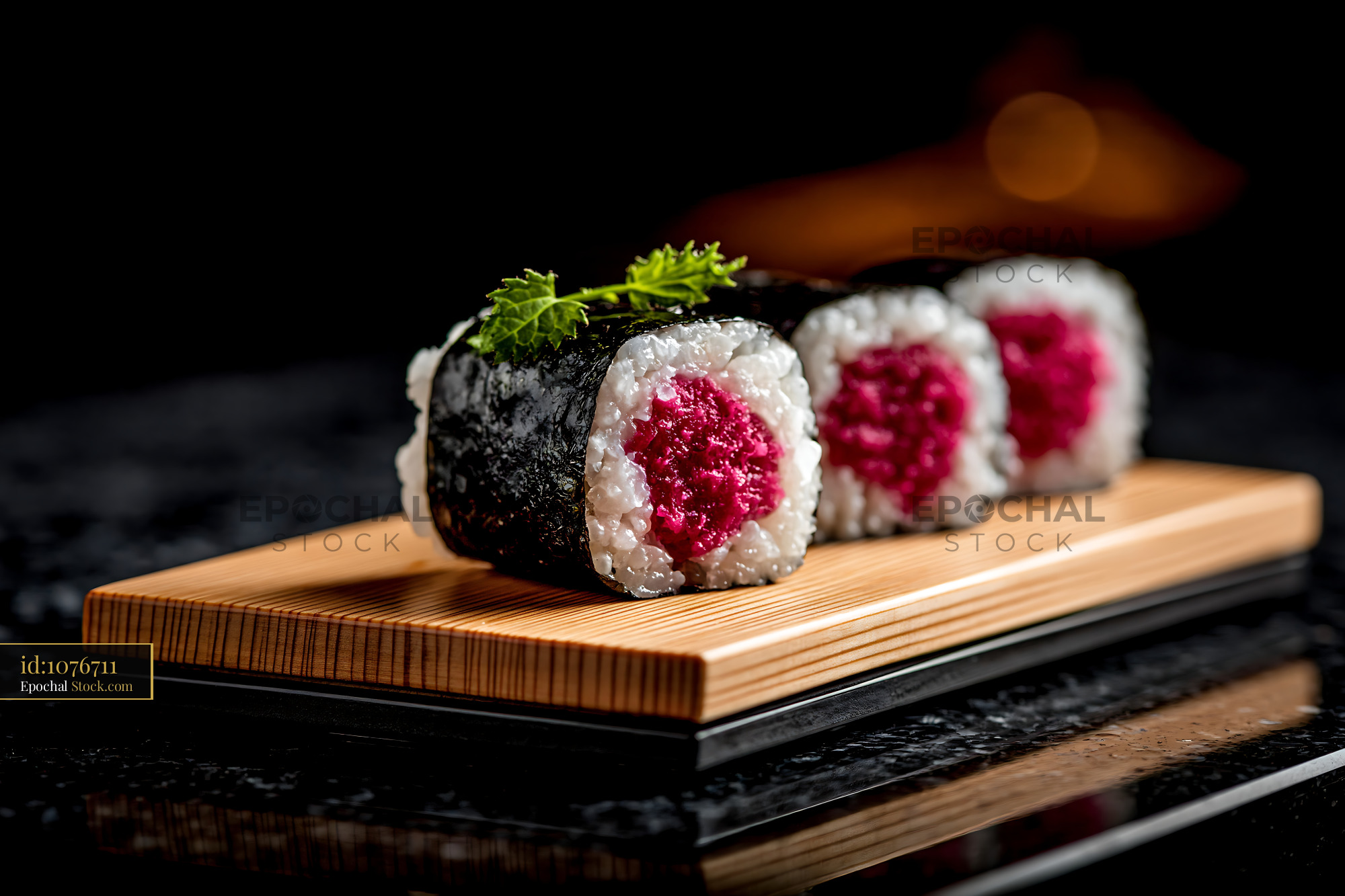 Salted plum umeboshi sushi rolls on a wooden board in a dark setting - stock photo