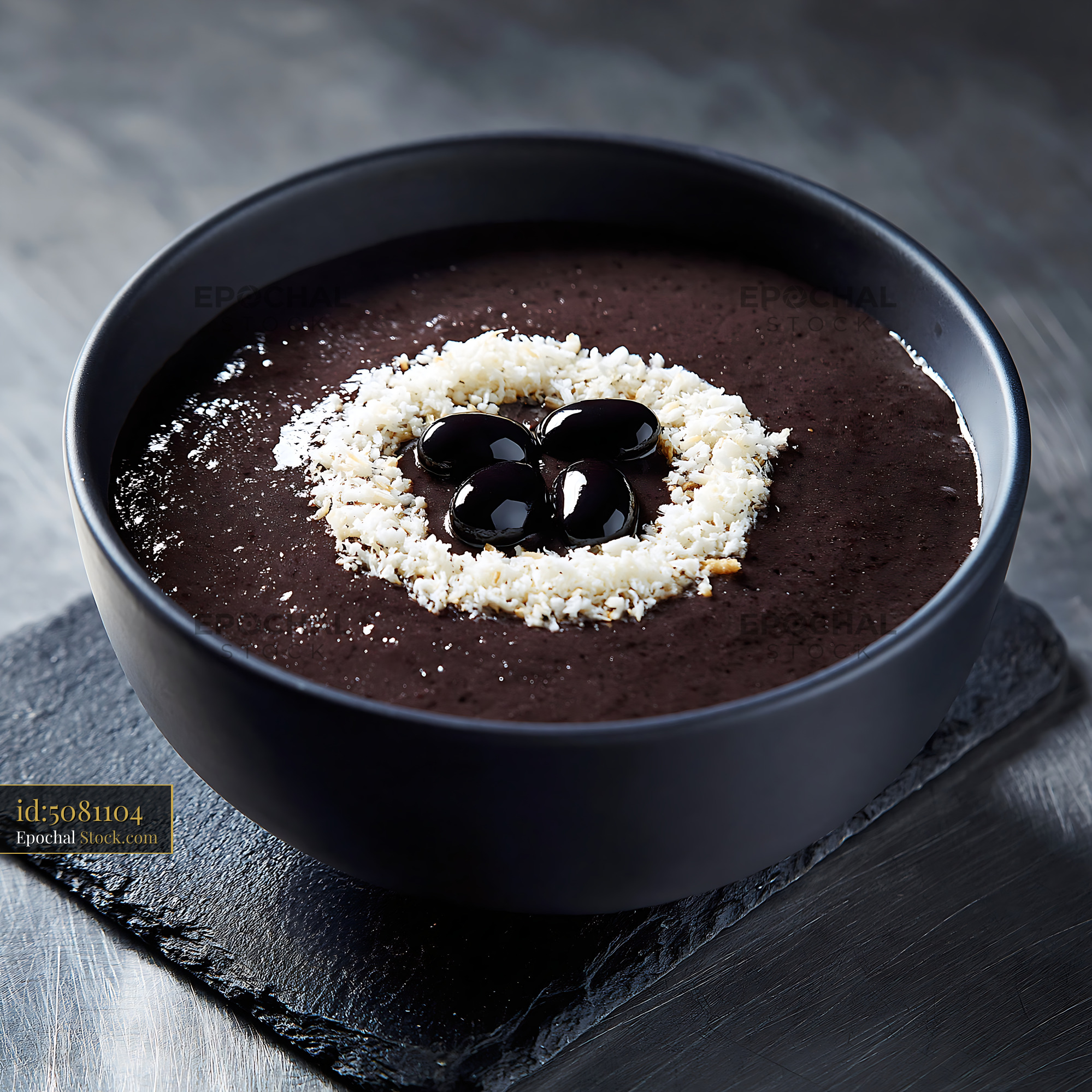 Black bean smoothie topped with coconut flakes in a dark bowl - stock photo