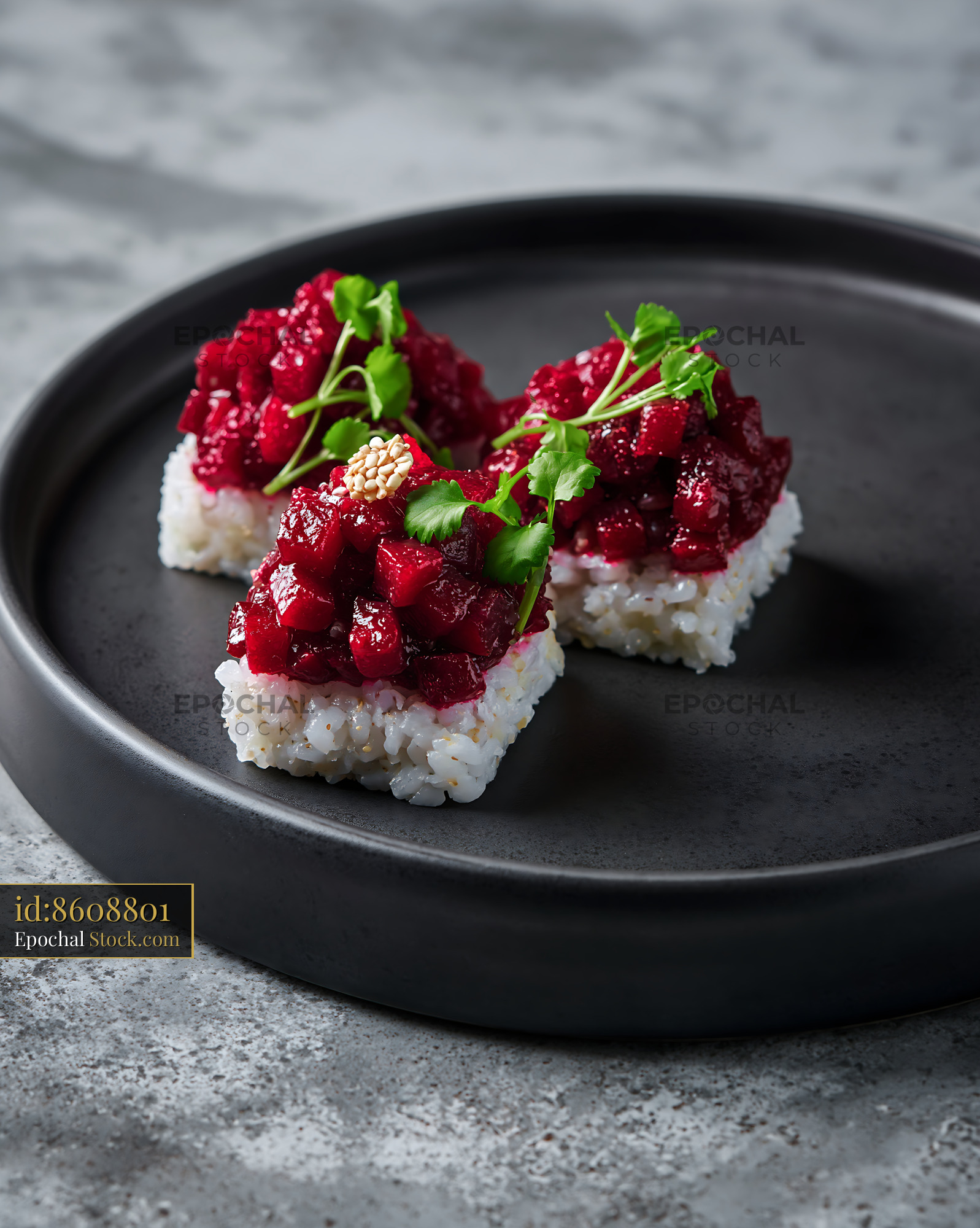 Vegan beet tartare sushi squares with microgreens on a black plate - stock photo
