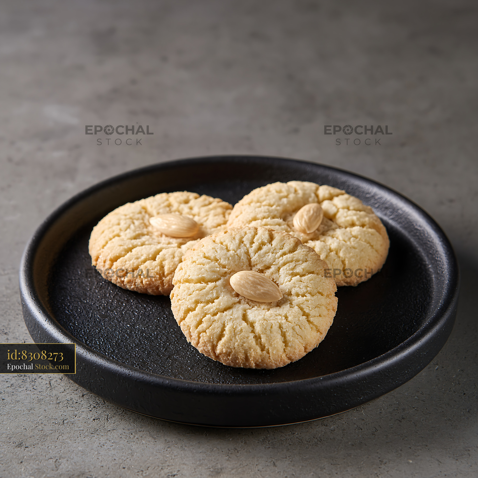 Acibadem kurabiyesi biscuits with whole almonds on a black plate - stock photo