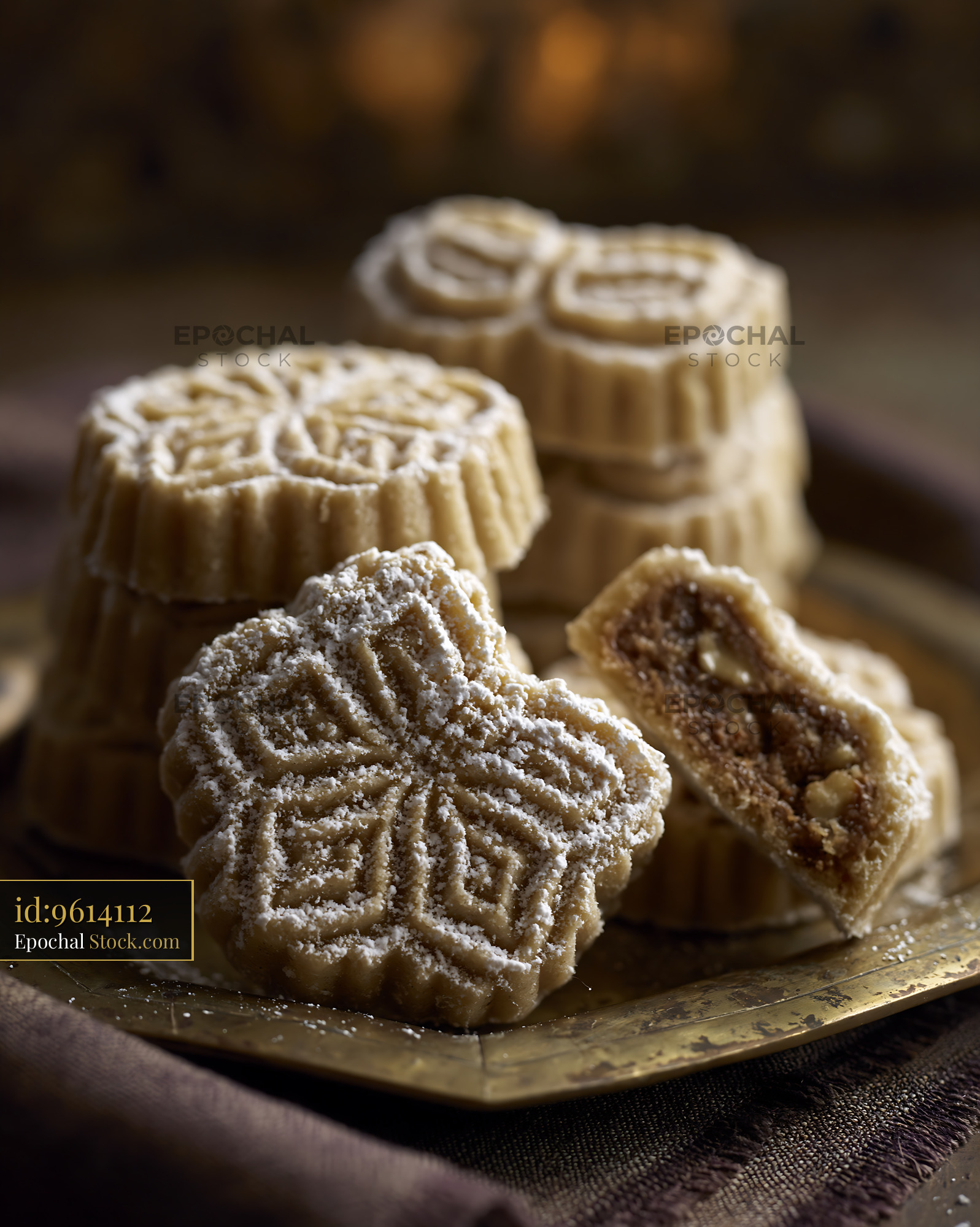 Traditional walnut maamoul biscuits with powdered sugar on a brass pla - stock photo