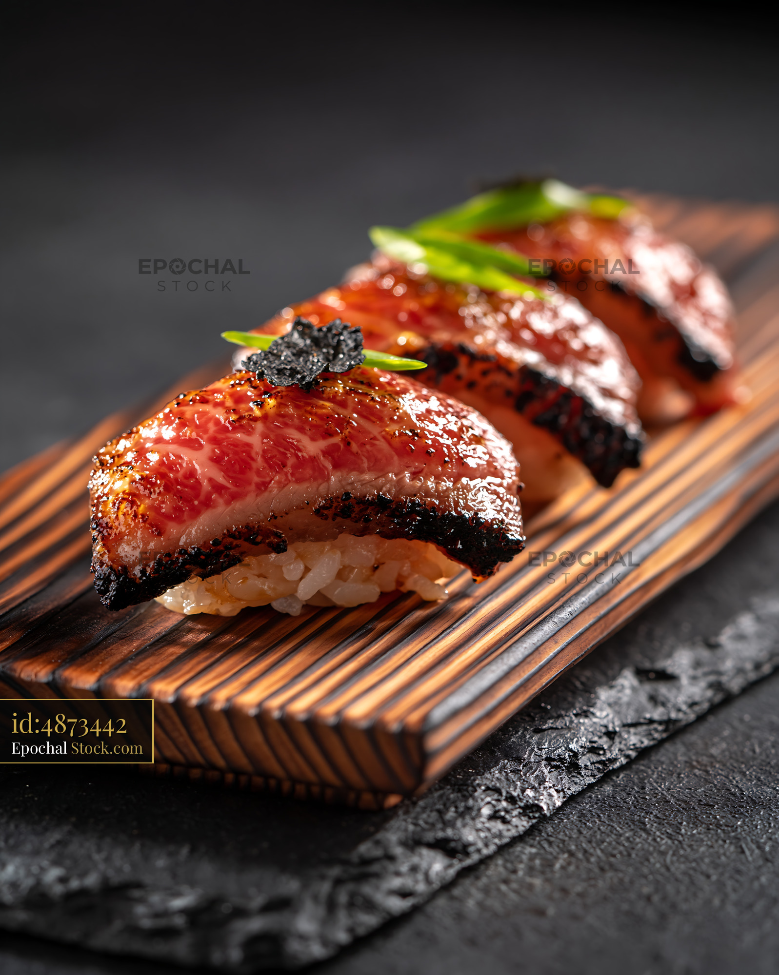 Flame-seared aburi wagyu sushi with truffle on wooden board - stock photo