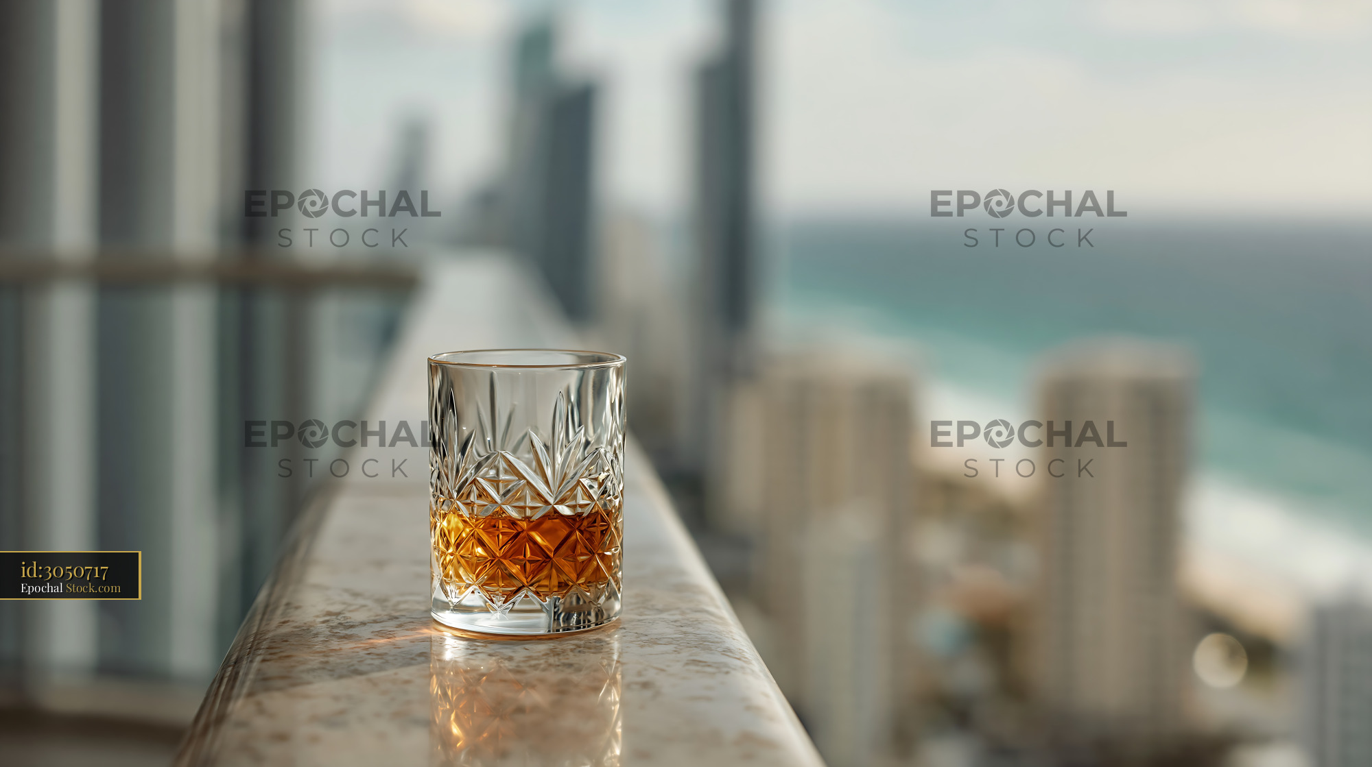 Crystal whiskey glass on a luxury hotel balcony with ocean view - stock photo