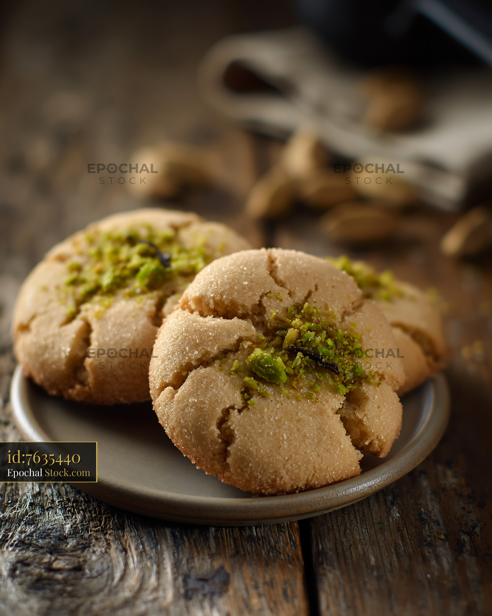 Cardamom chickpea biscuits with pistachio topping on a rustic table - stock photo