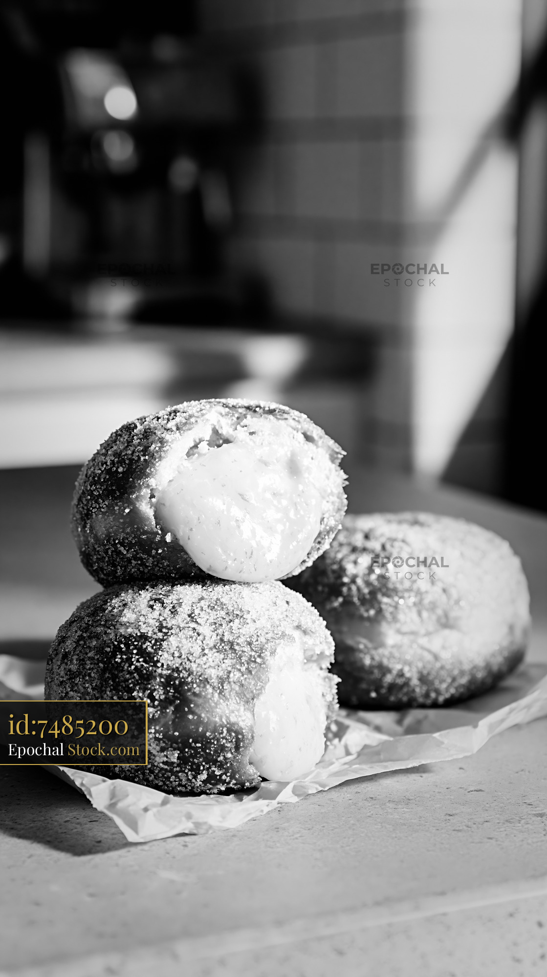 Stack of yuzu curd filled donuts with sugar coating in black and white - stock photo