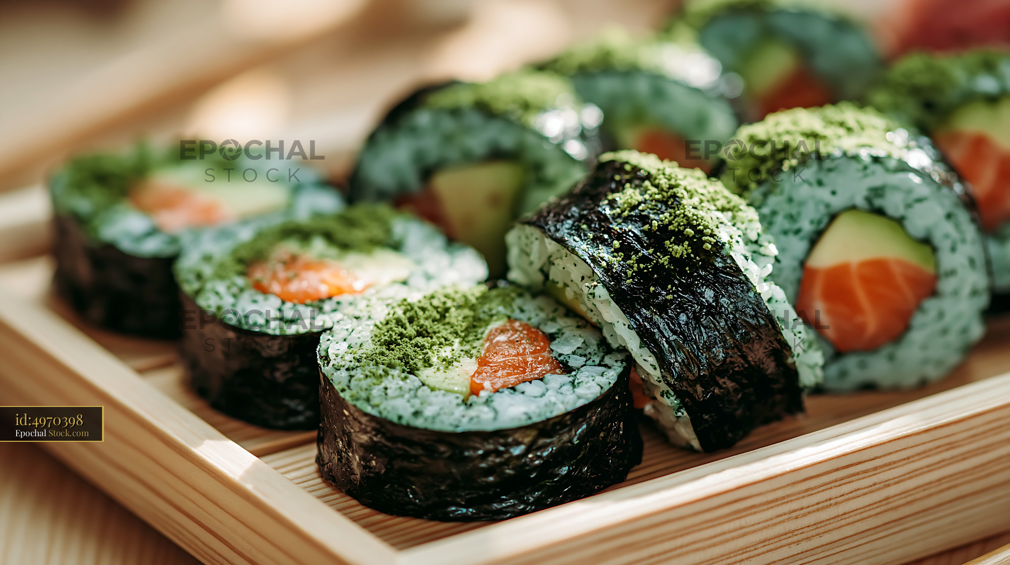 Sushi rolls with salmon and avocado topped with green spirulina powder - stock photo