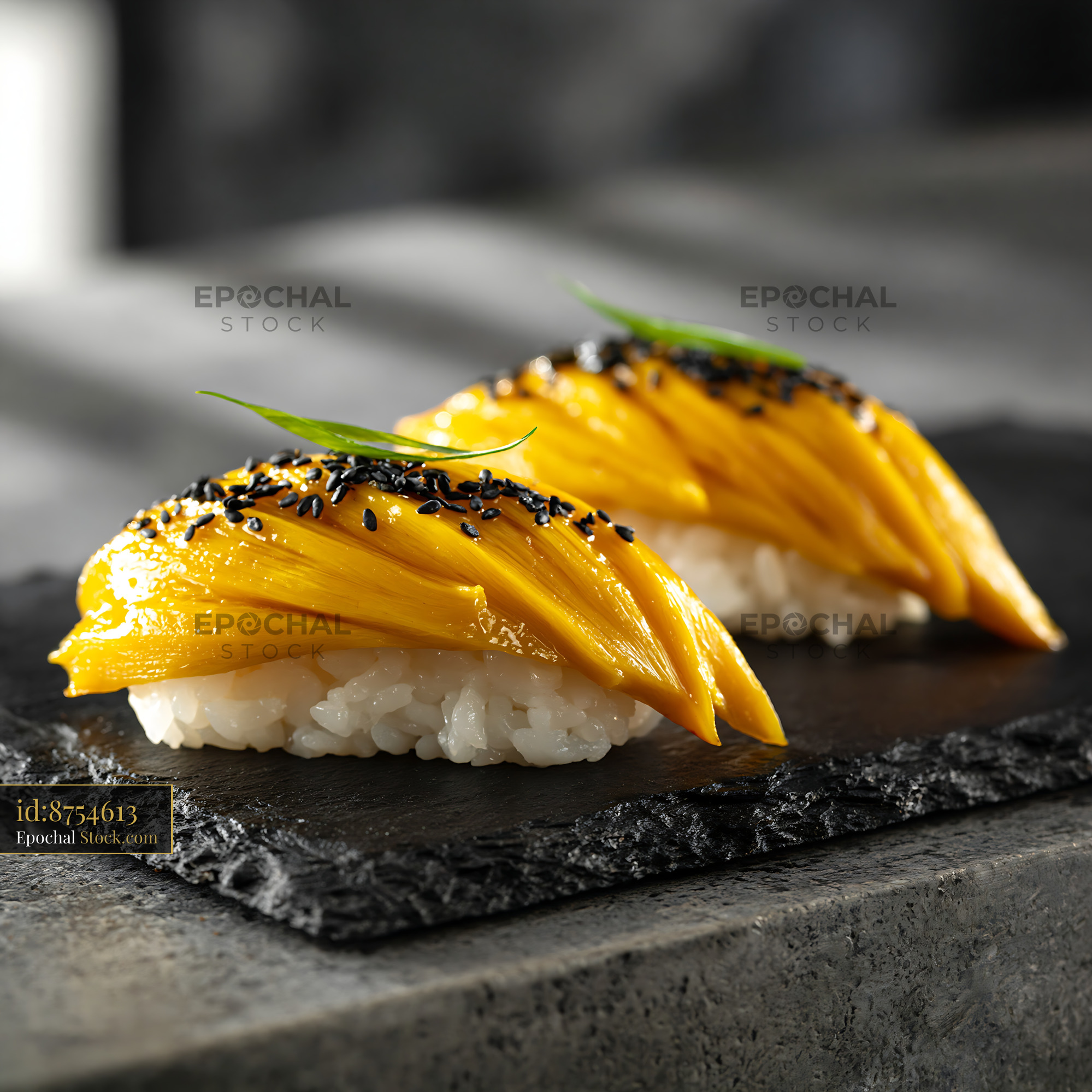 Two pieces of jackfruit nigiri sushi with black sesame on slate - stock photo