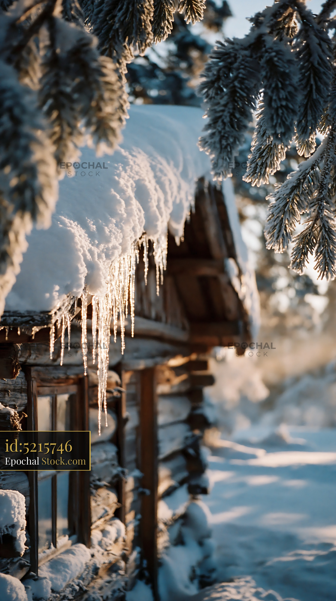 Wooden log cabin covered in thick snow with icicles at sunrise - stock photo