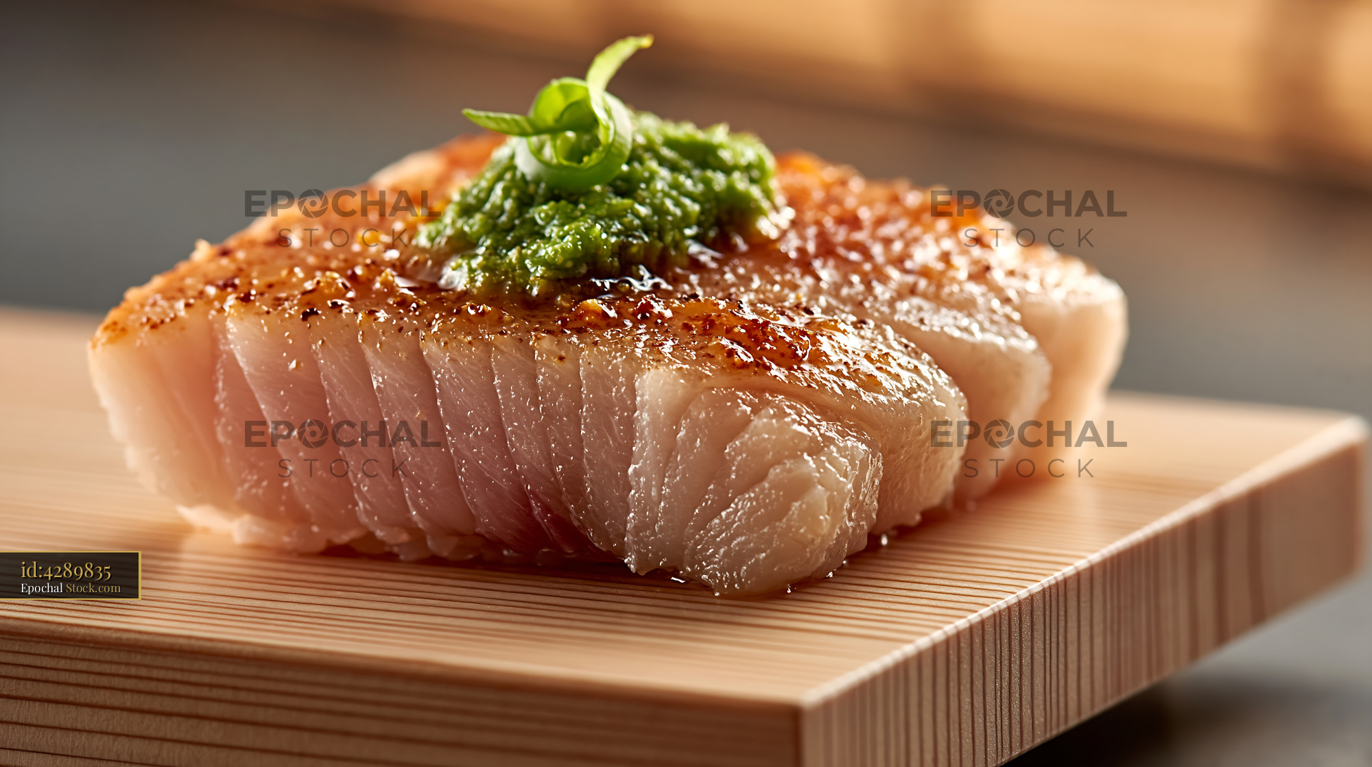 Seared yellowtail sushi topped with yuzu kosho on a wooden block - stock photo