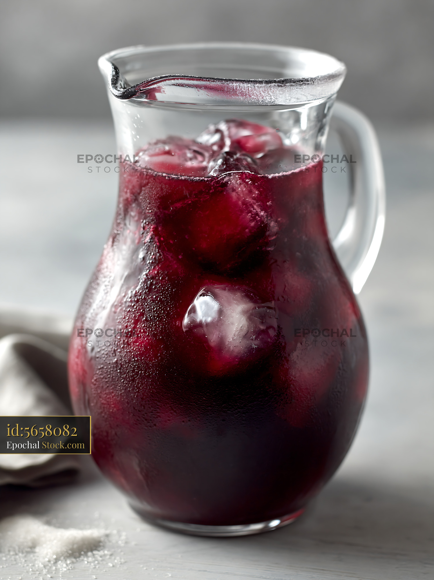 Cold berry lemonade pitcher with ice cubes and condensation - stock photo
