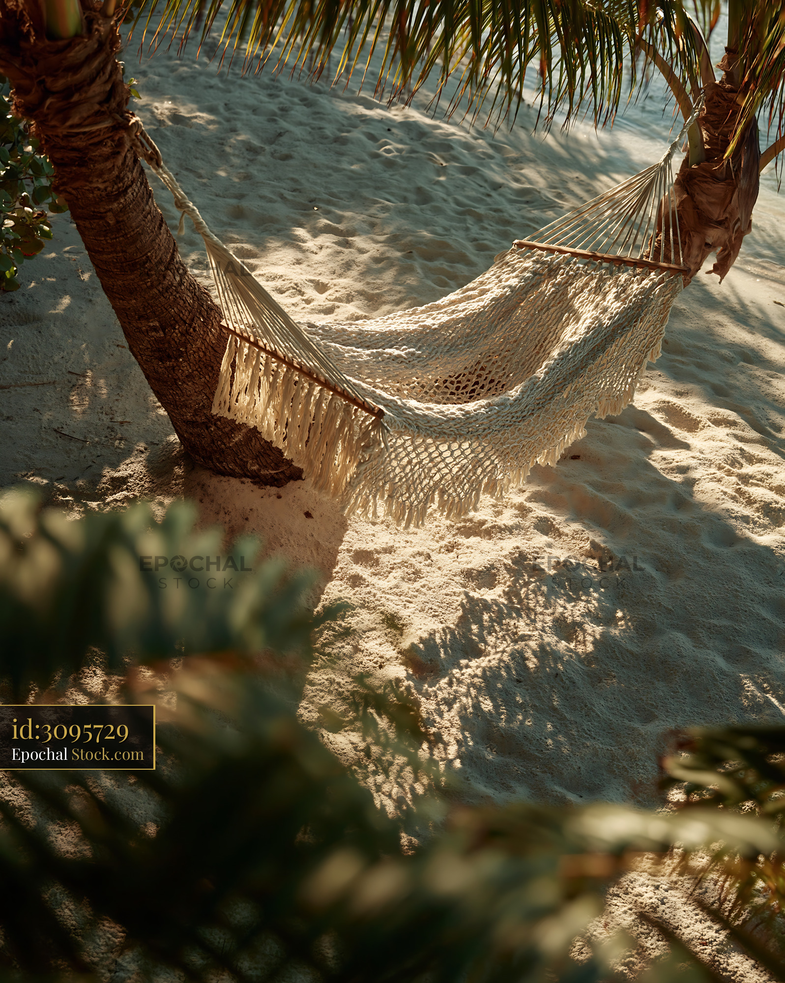 White macrame hammock between palm trees on a sunny tropical beach - stock photo