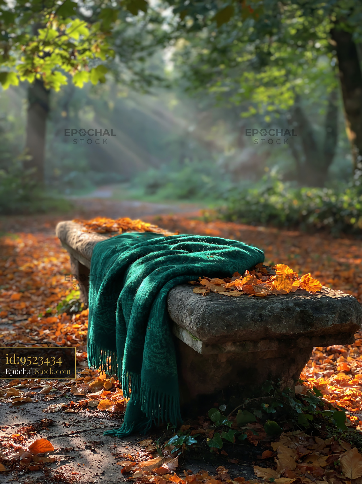 Green blanket on stone bench in autumn park with sunbeams - stock photo