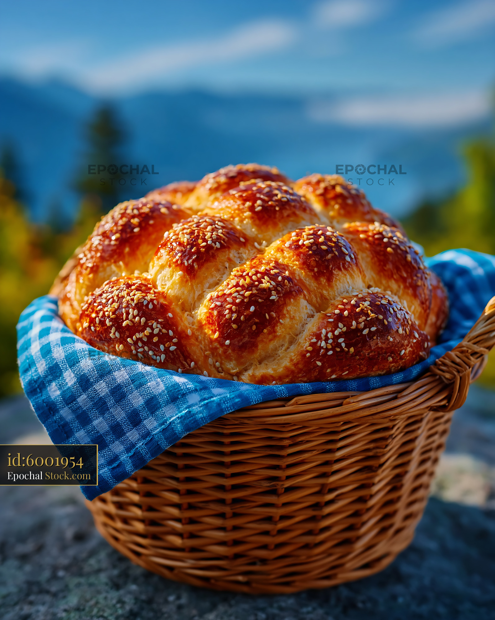 Golden braided bread in a basket with scenic mountain background - stock photo