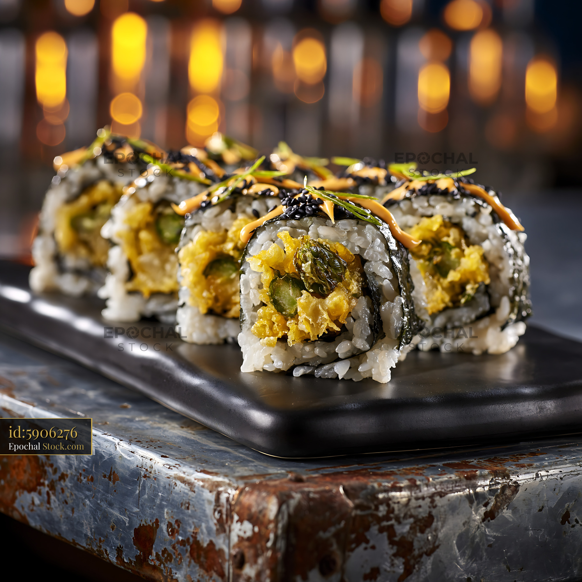 Tempura asparagus sushi rolls on a black platter in a restaurant - stock photo