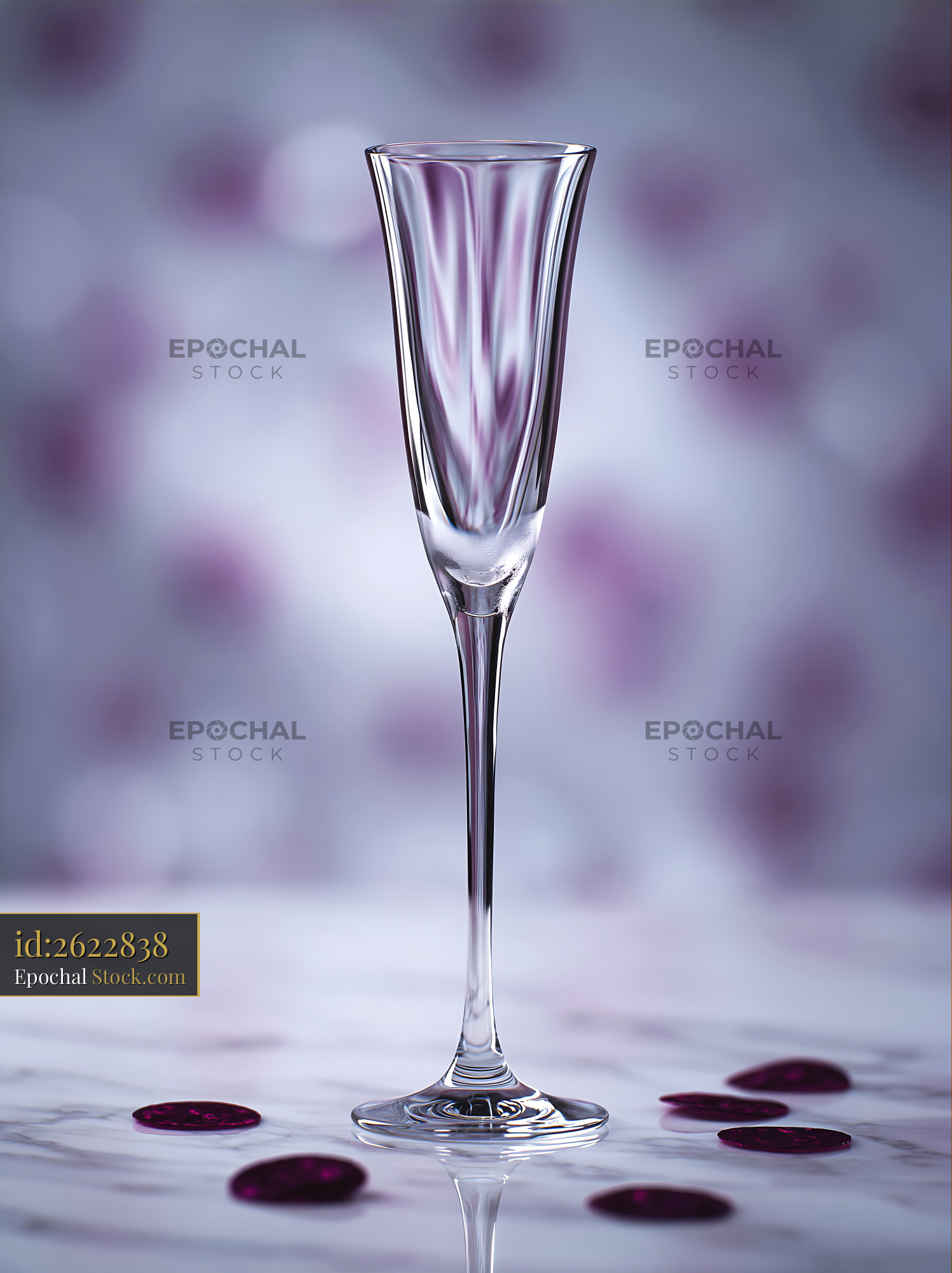 Elegant empty champagne flute on marble surface with purple bokeh - stock photo