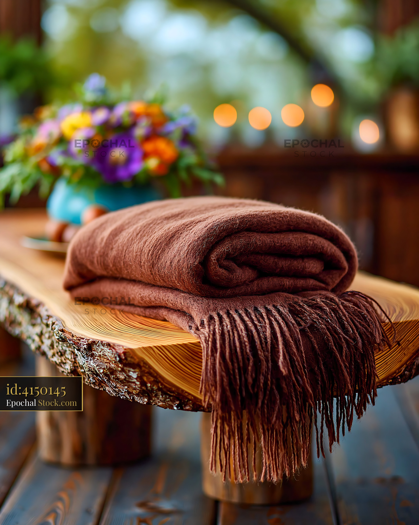 Brown cashmere throw on rustic wooden bench in a cozy garden setting - stock photo