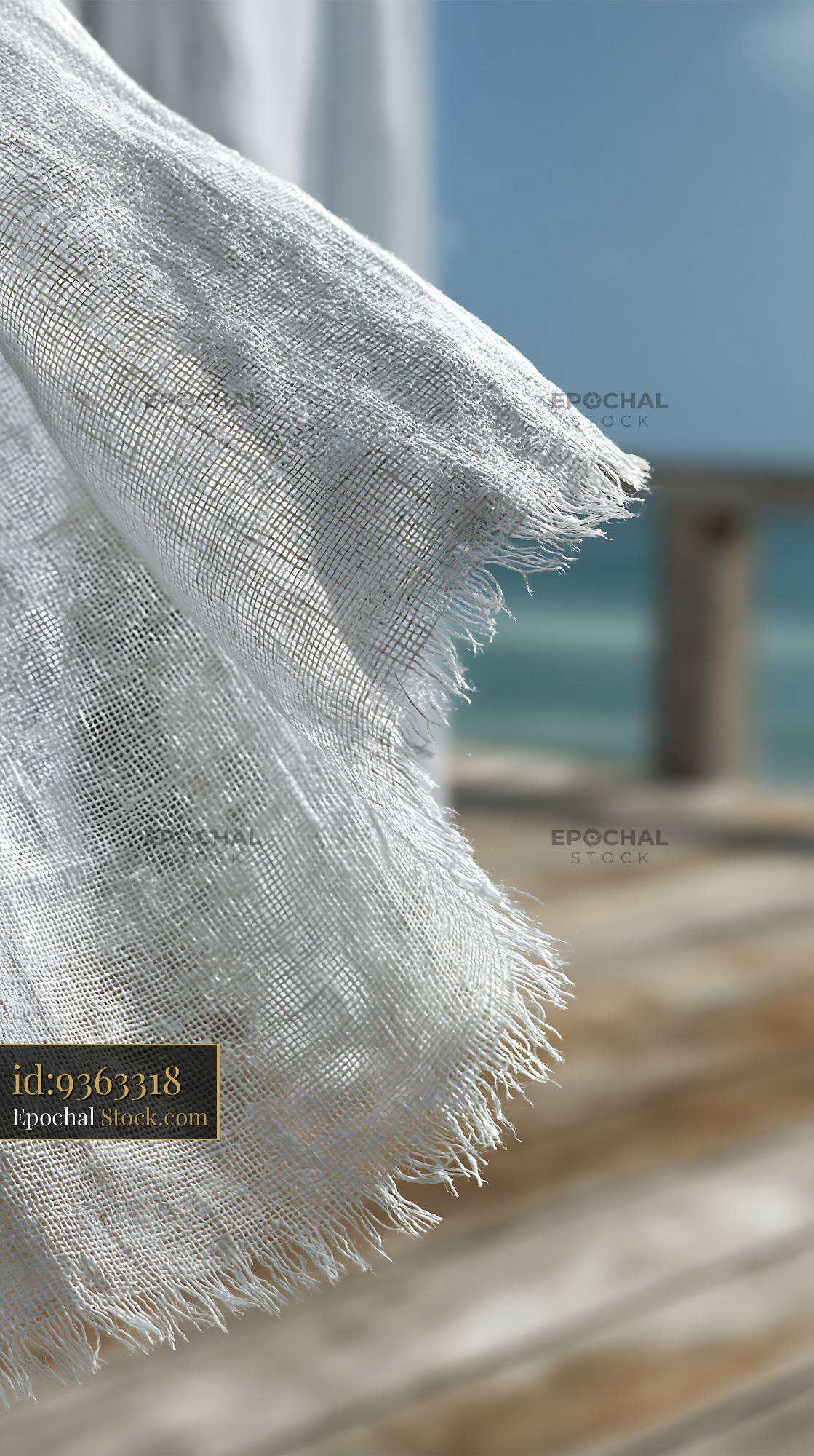 White linen curtain blowing in the breeze on a sunny coastal deck - stock photo