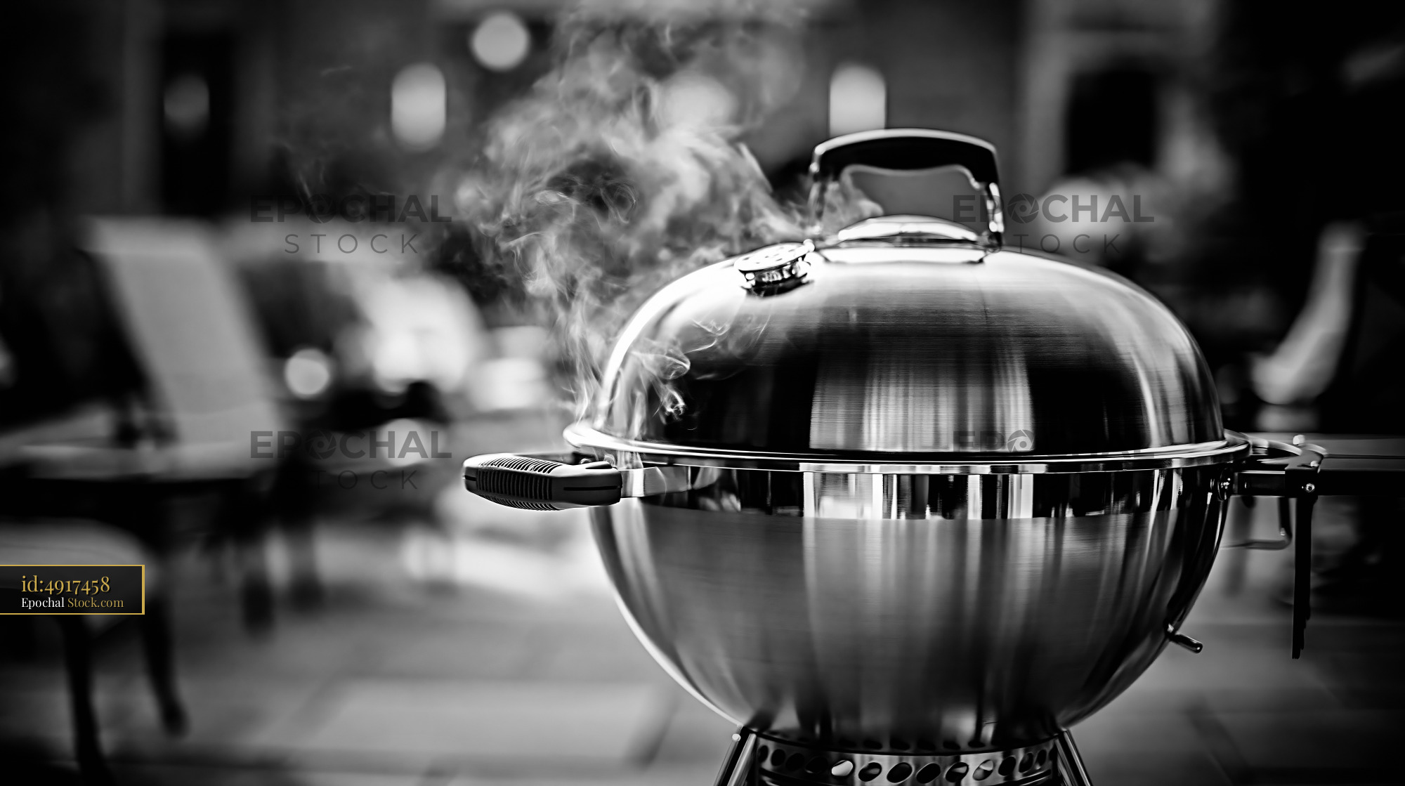 Kettle grill with rising steam at a summer garden party - stock photo