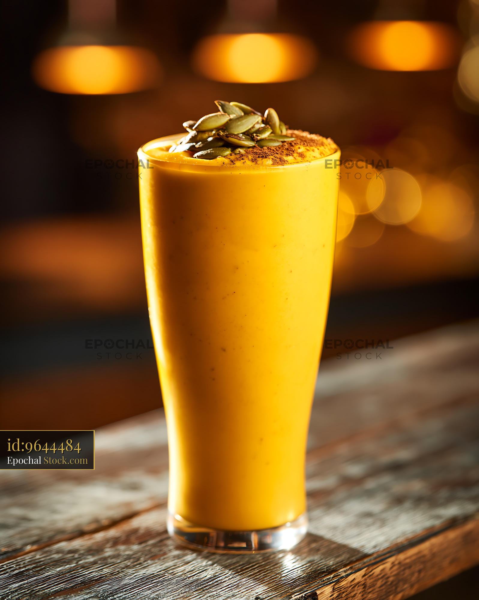 Creamy kabocha pumpkin smoothie topped with pepitas in a tall glass - stock photo