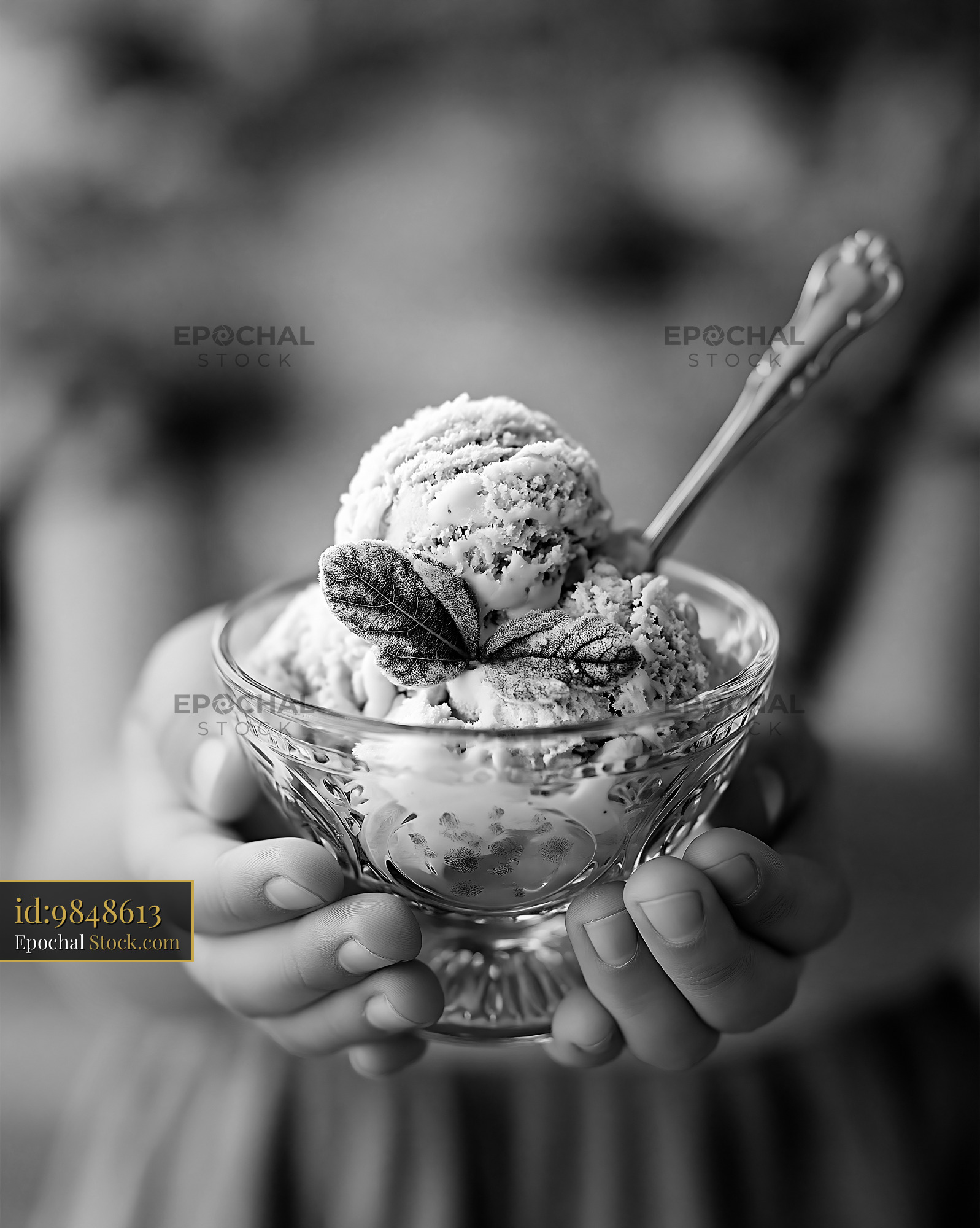 Hands holding a glass bowl of artisanal fig leaf ice cream - stock photo