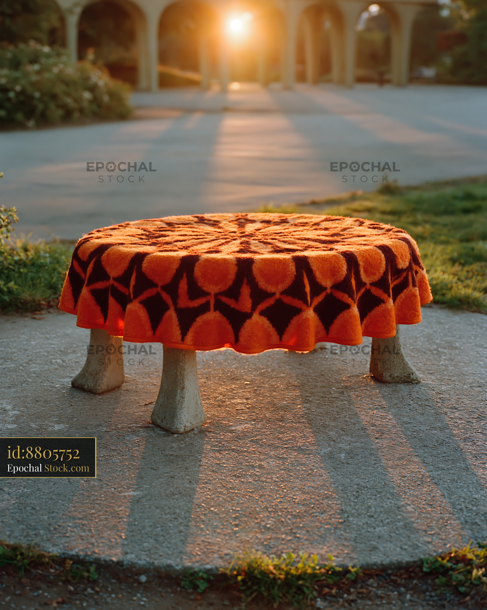 Patterned blanket park seat on a concrete stool at golden hour - stock photo