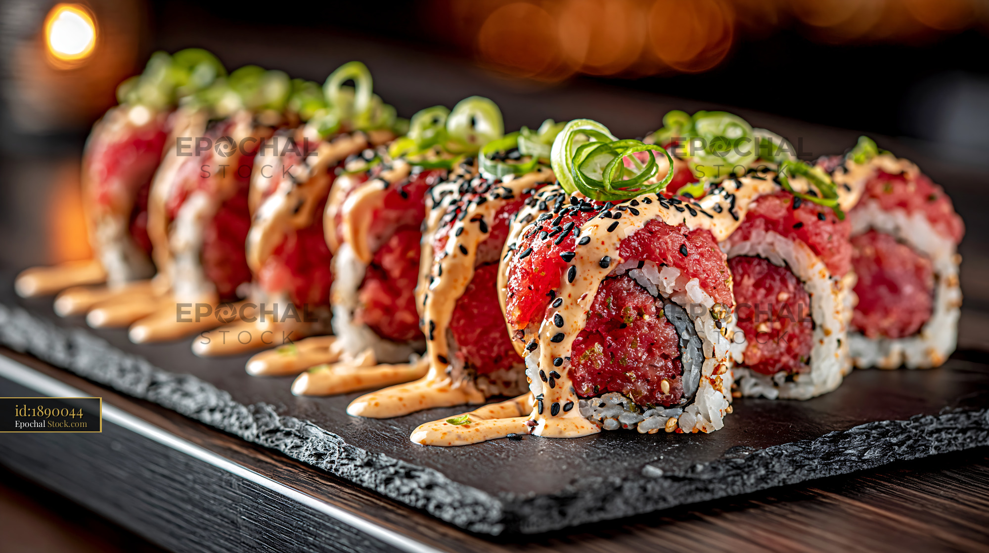 Spicy sriracha mayo tuna sushi rolls topped with fresh scallions - stock photo