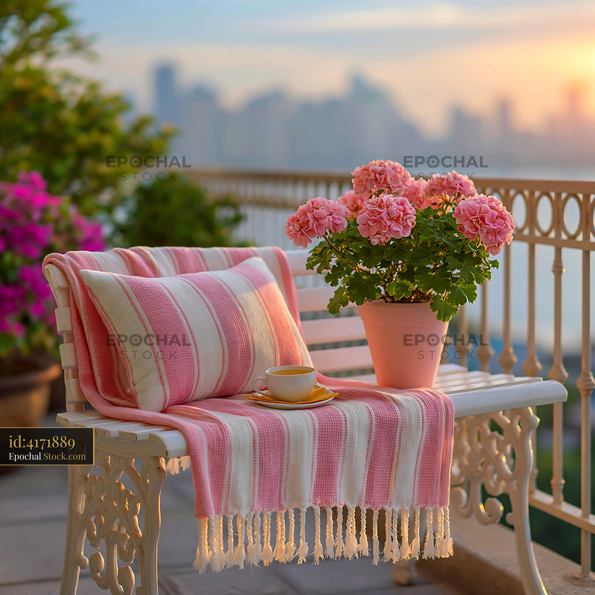 Pink striped throw on bench with tea and flowers at sunset balcony - stock photo