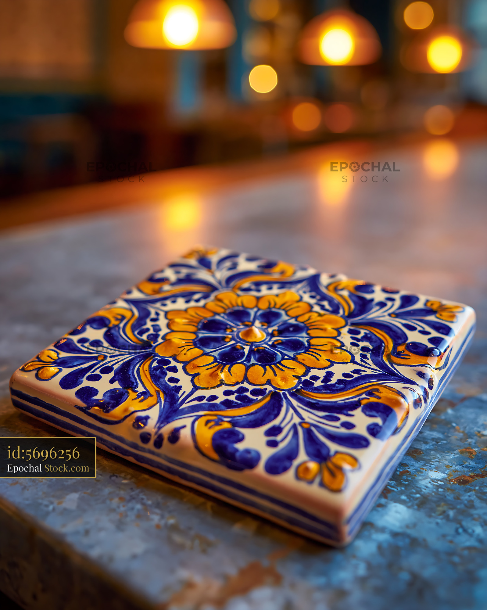 Traditional blue and yellow ceramic tile on a rustic stone counter - stock photo