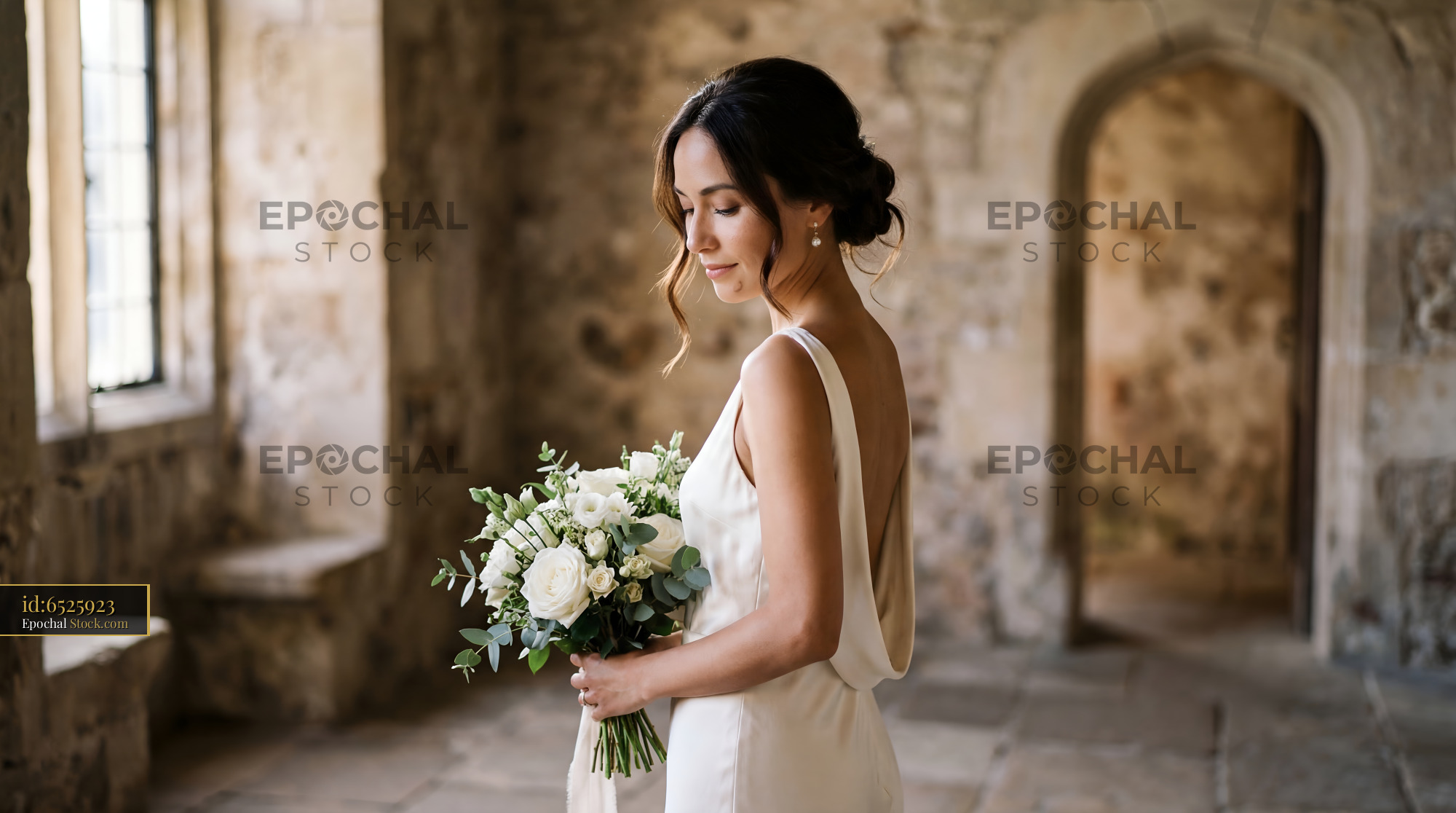Bride holding bouquet in a stone hall before the wedding Premium Stock Photo - stock photo
