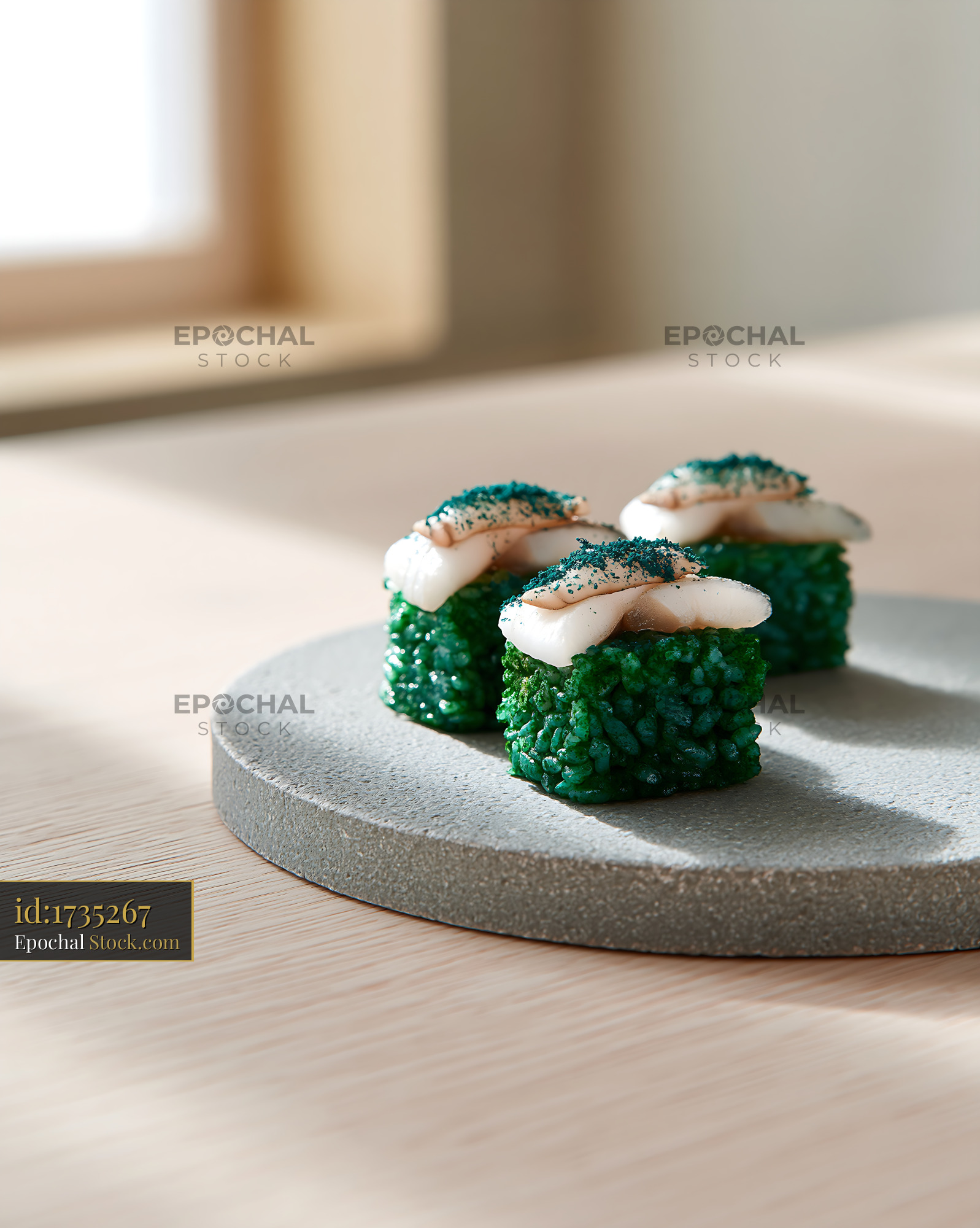 Gourmet sushi with green spirulina rice and seafood on stone plate - stock photo
