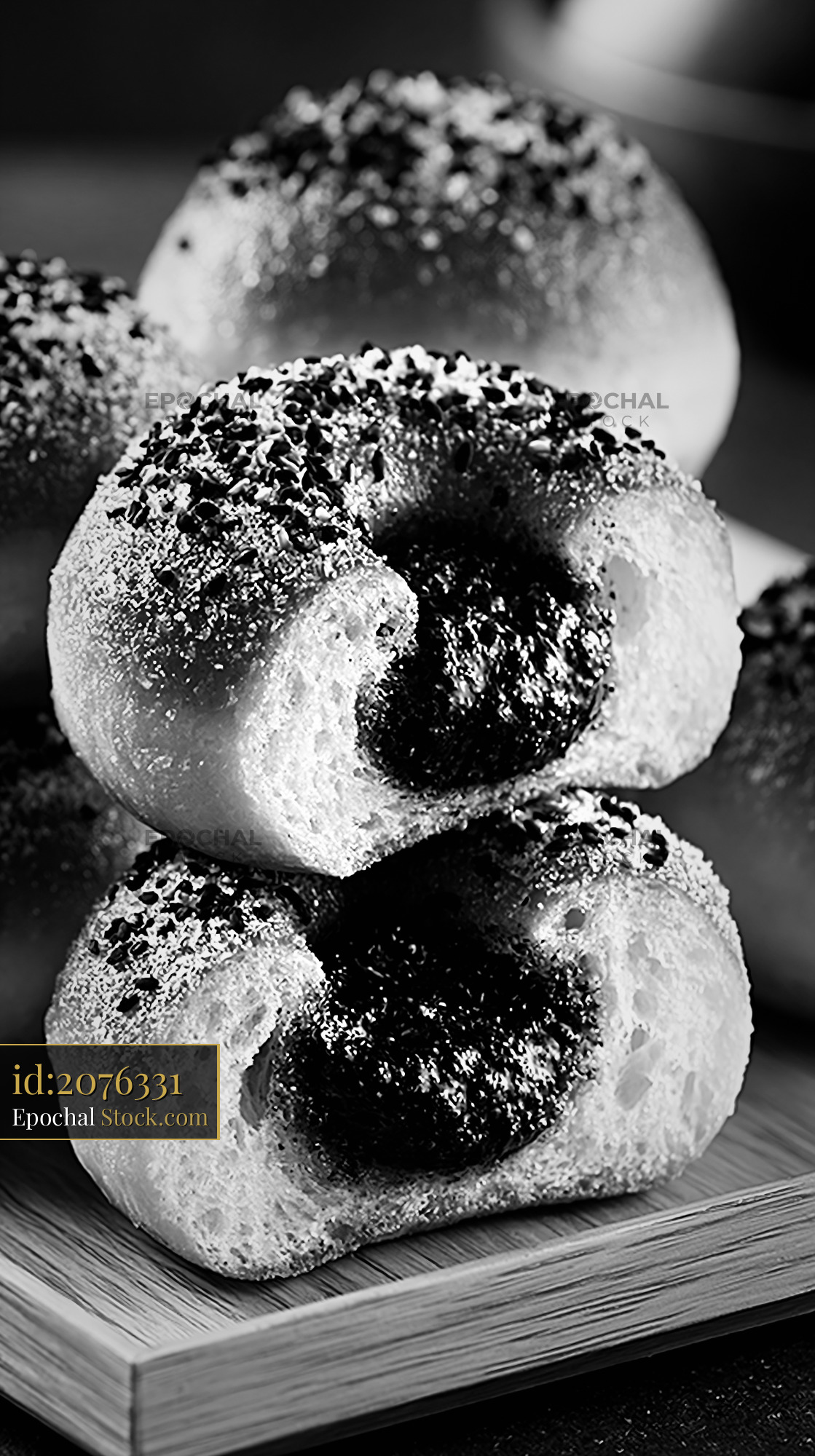 Artisanal black sesame paste filled donuts on a wooden tray - stock photo