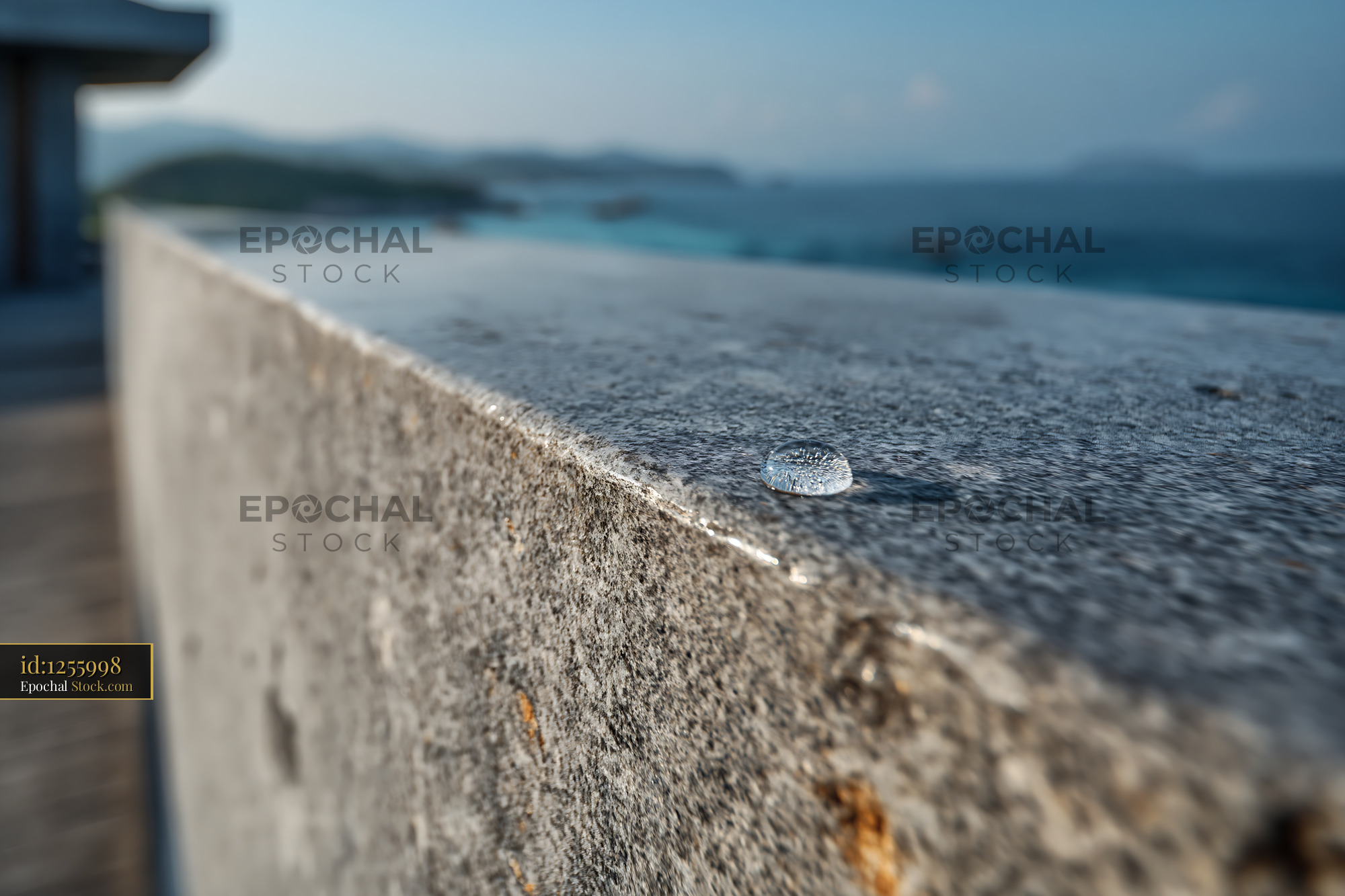Single water droplet on granite railing with luxury hotel balcony view - stock photo