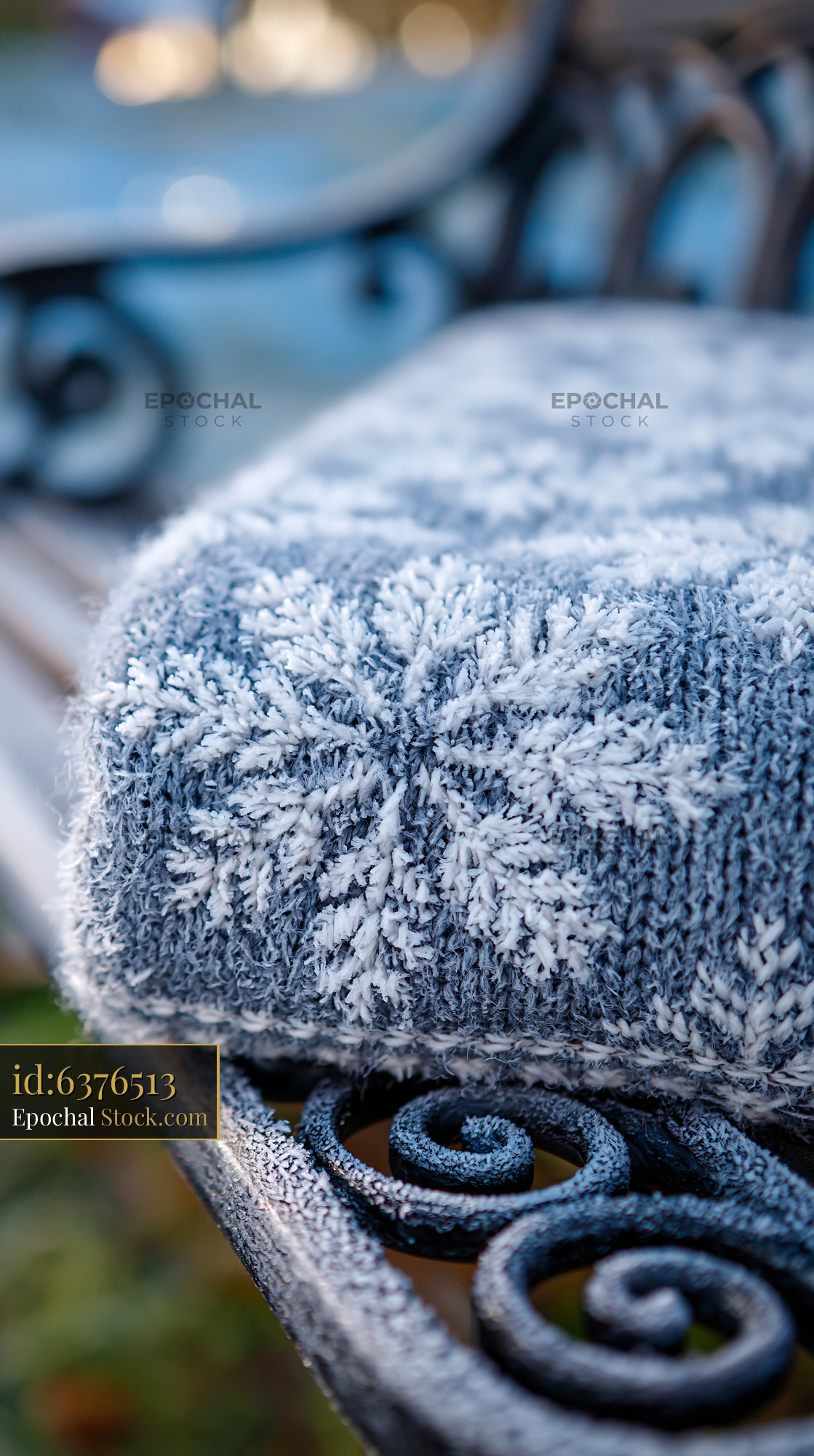 Knitted snowflake throw on a frosted garden bench on a cold morning - stock photo