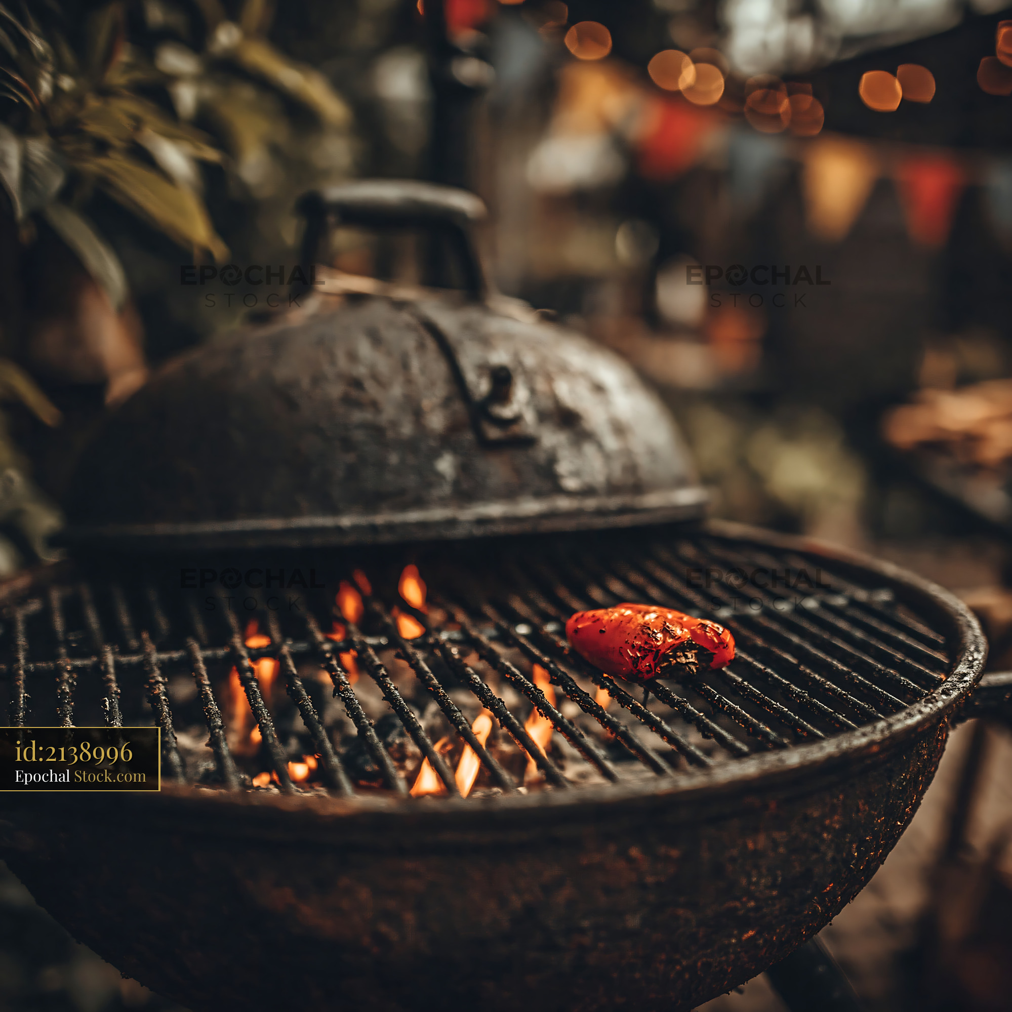 Red bell pepper roasting on a charcoal grill at a garden party - stock photo