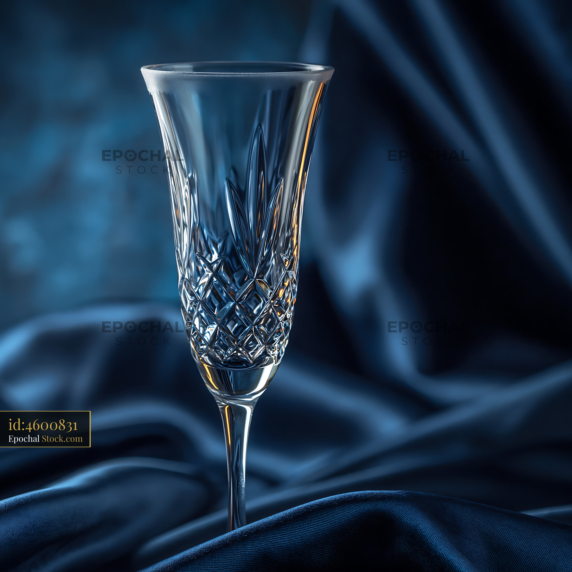 Elegant empty crystal champagne flute on draped midnight blue silk - stock photo