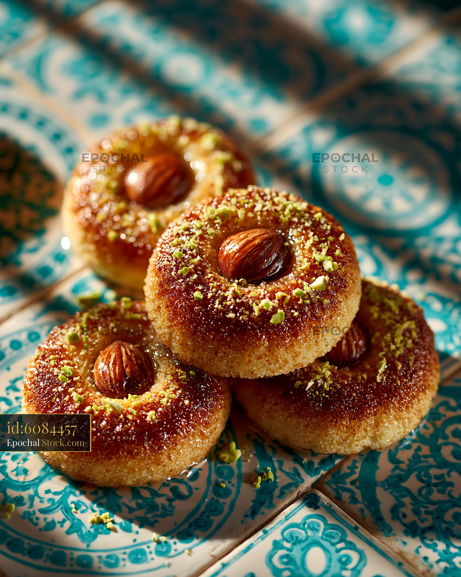 Sekerpare hazelnut biscuits with syrup and pistachios on blue tiles - stock photo